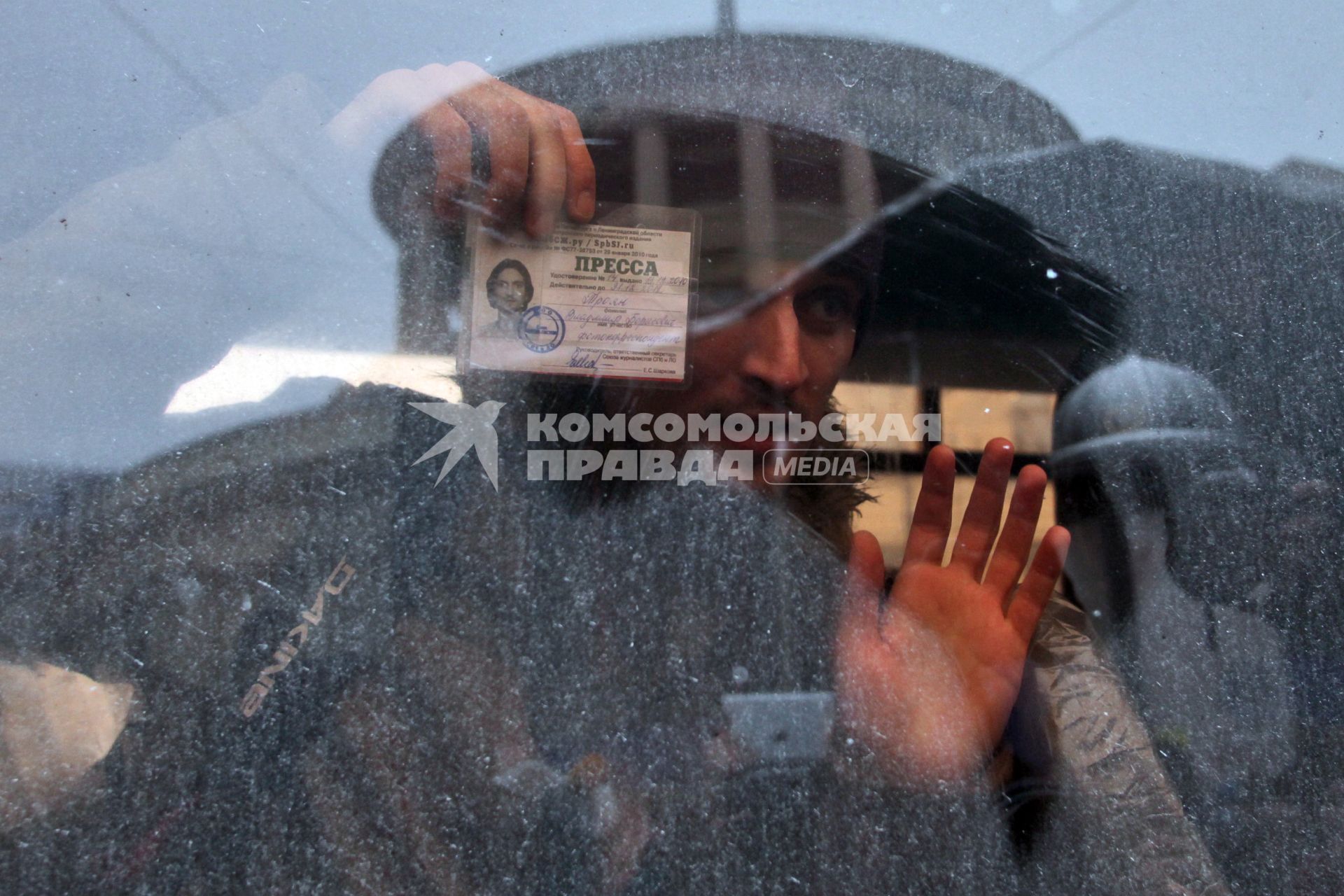 Митинг за честные выборы. Мужчина журналист сидя в автозаке показывает удостоверение прессы.