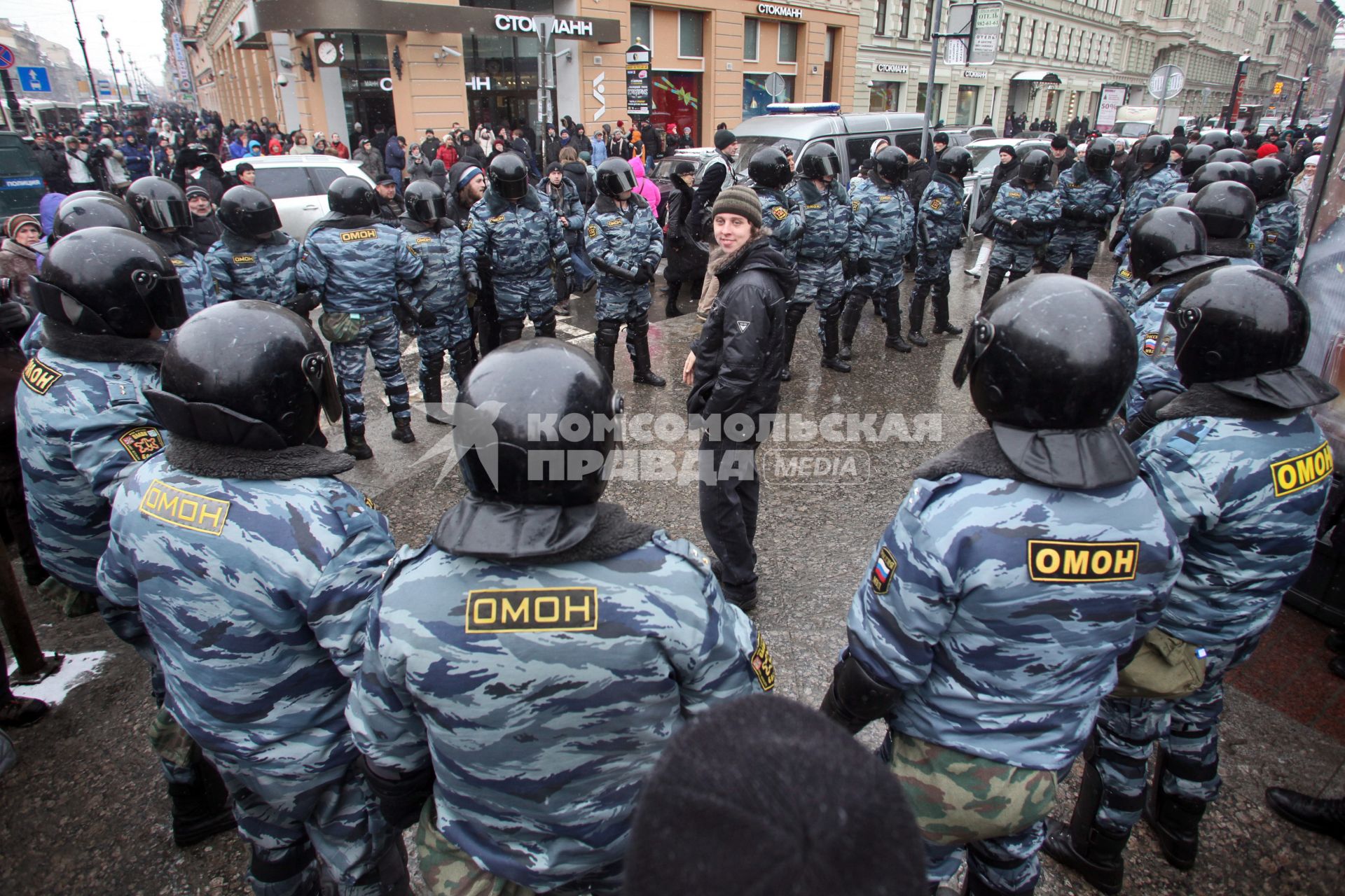 Митинг за честные выборы. Мужчина стоит в кольце из сотрудников ОМОНа.