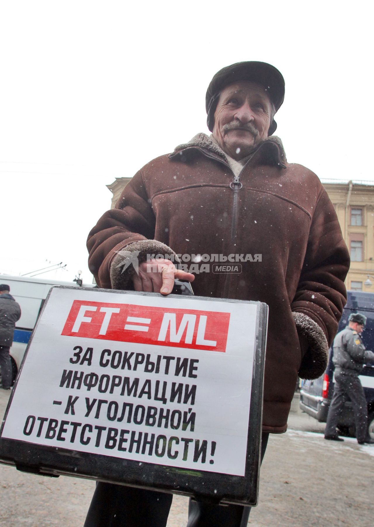 Митинг за честные выборы. Мужчина стоит с плакатом на кейсе, надпись: `За сокрытие информации - к уголовной ответственности`.