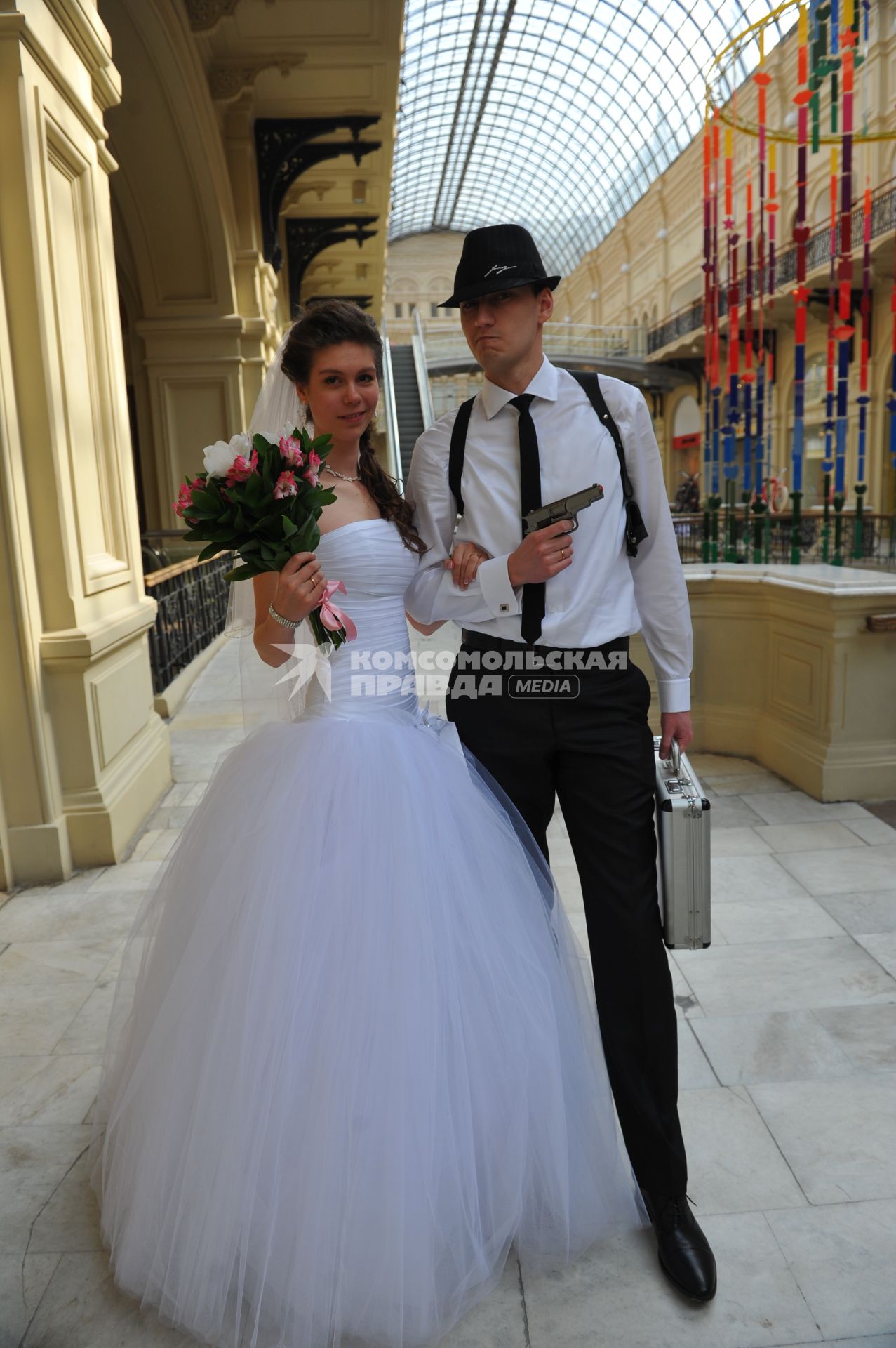 Свадьба. На снимке: жених с пистолетом и невеста с букетом.