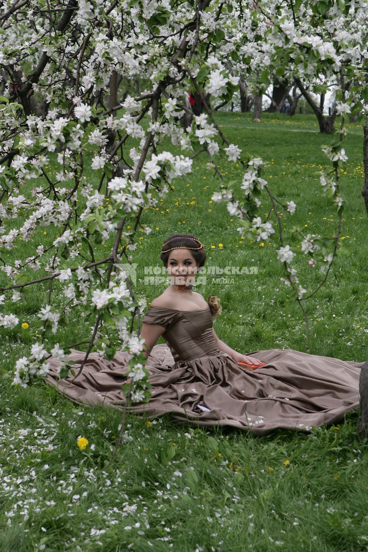 Музей-заповедник `Коломенское`. На снимке: девушка позирует фотографу в яблоневом саду.