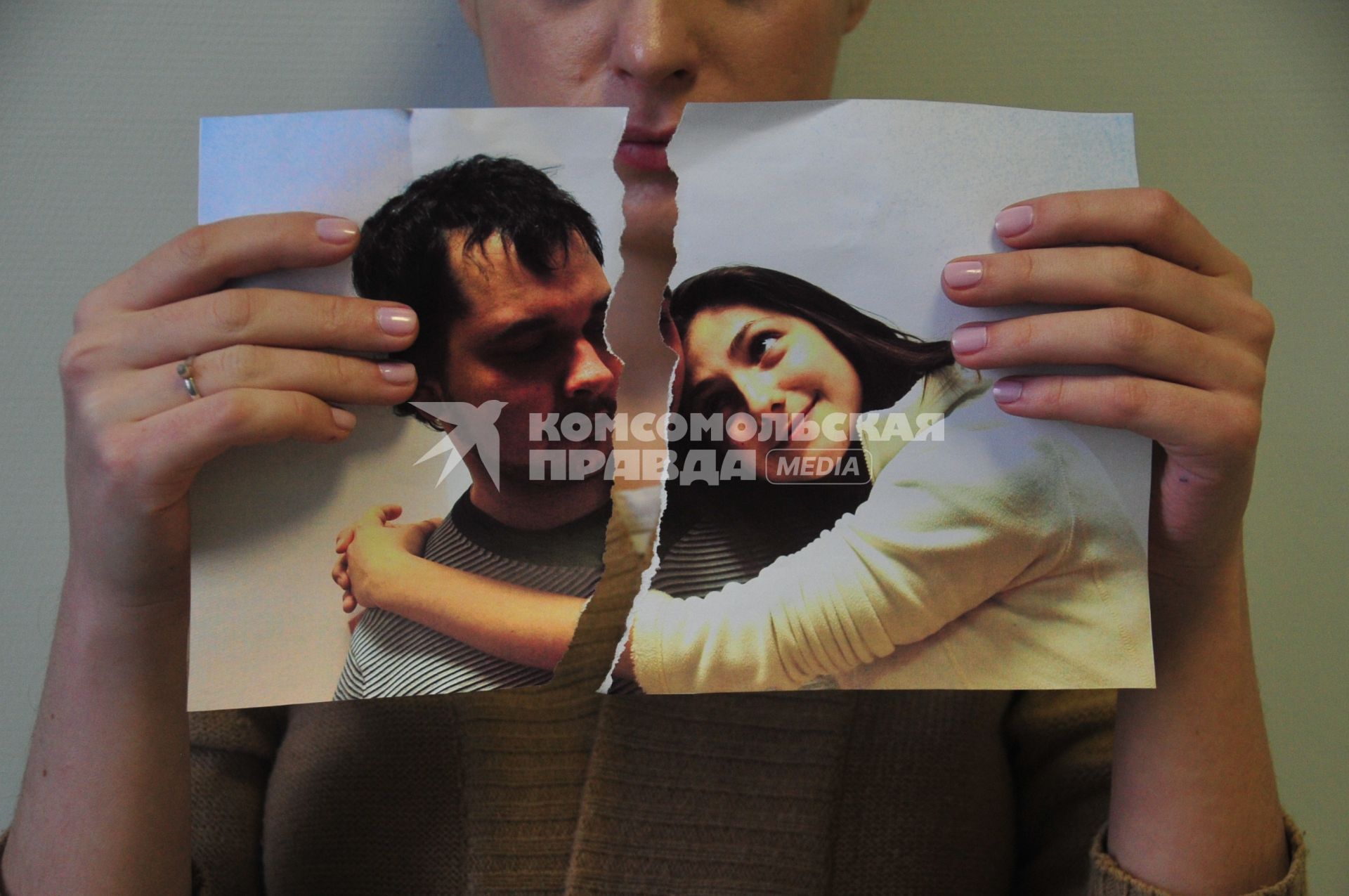 Жанровая фотография. На снимке: девушка разрывает фотографию, изображающую влюбленную пару.