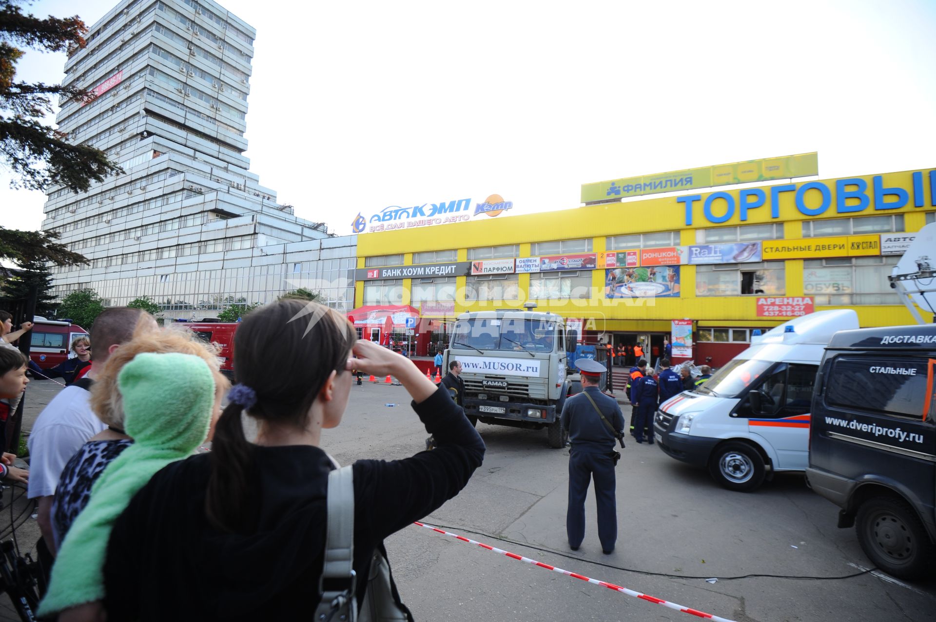 В торговом центре `Мичуринский` на Озерной улице, дом 42 произошло обрушение межэтажных конструкций, а затем и кровли. На снимке: Люди наблюдают за работой из-за ограждения.