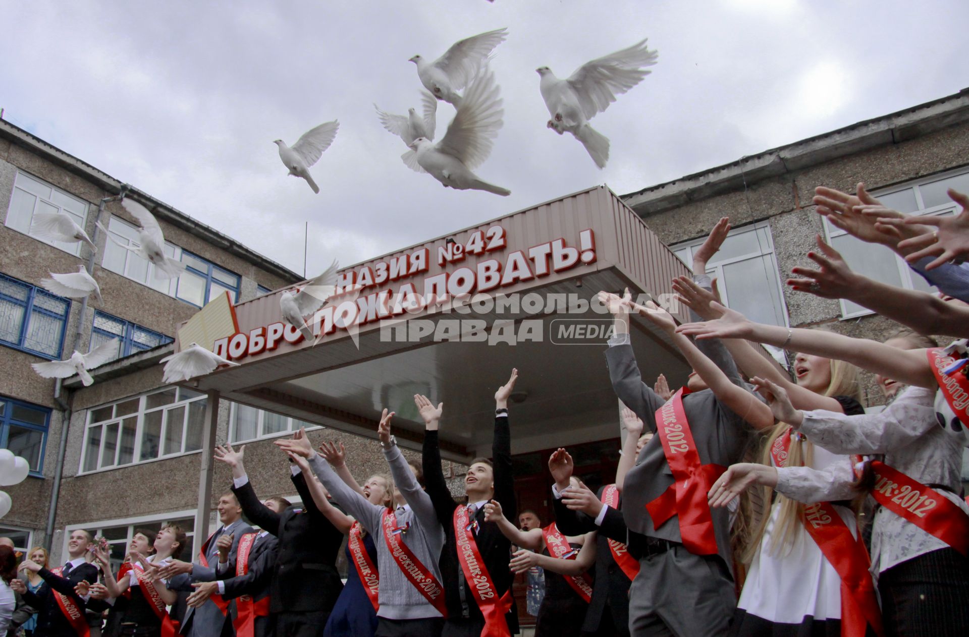 Выпускники выпускают на волю белых голубей.