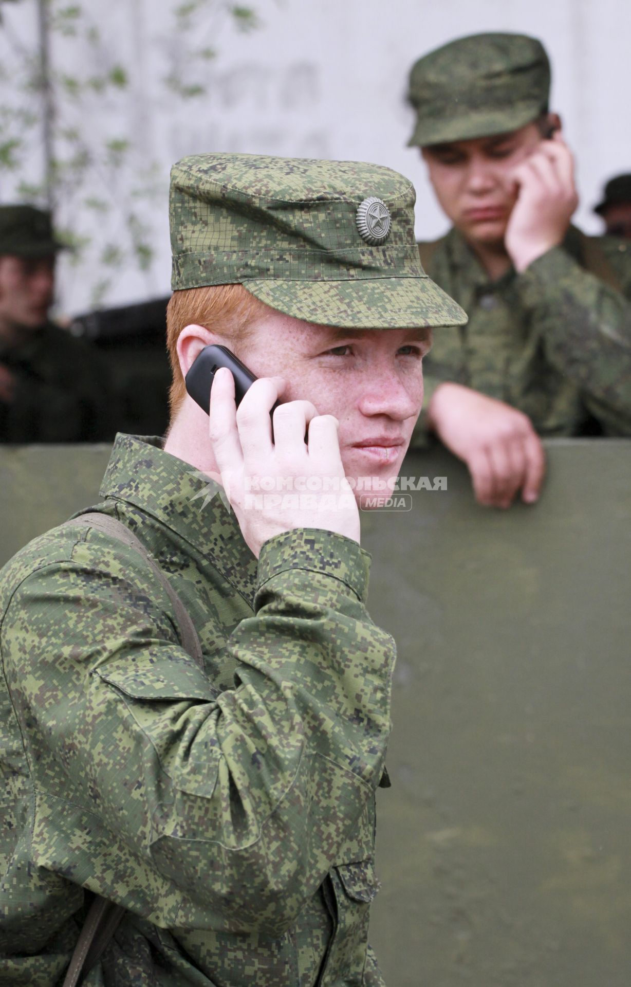 Призывник (солдат) с мобильным телефоном.