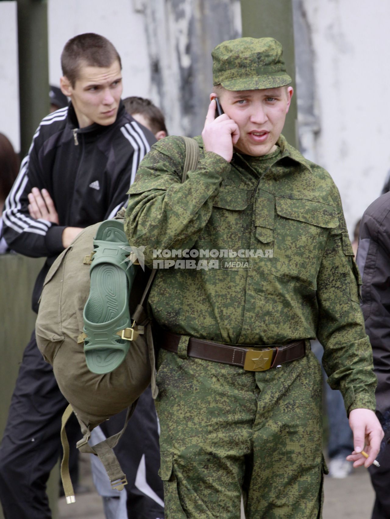 Призывник (солдат) с мобильным телефоном.