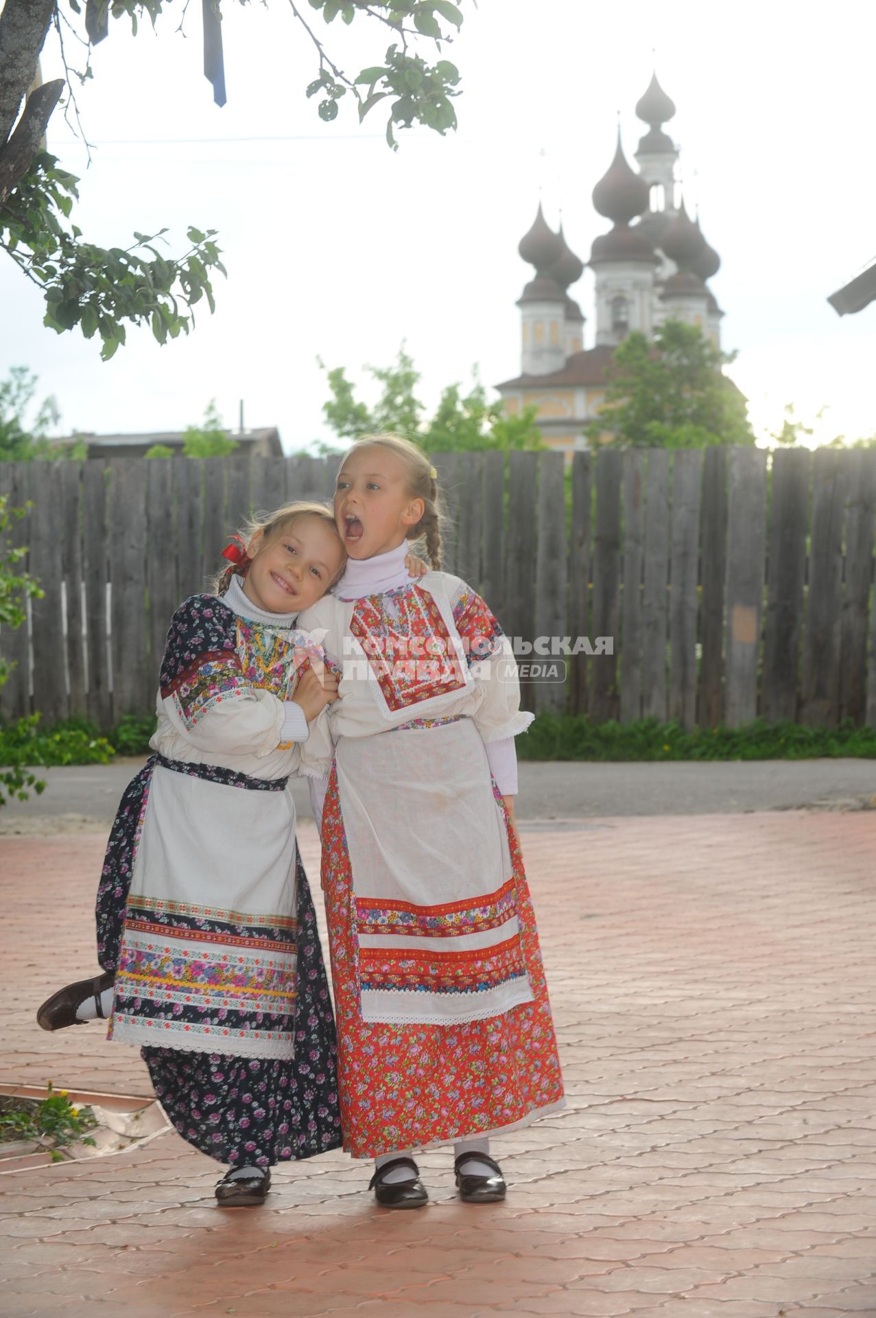 Девочки в русско- народных костюмах на русском подворье на фоне храма.