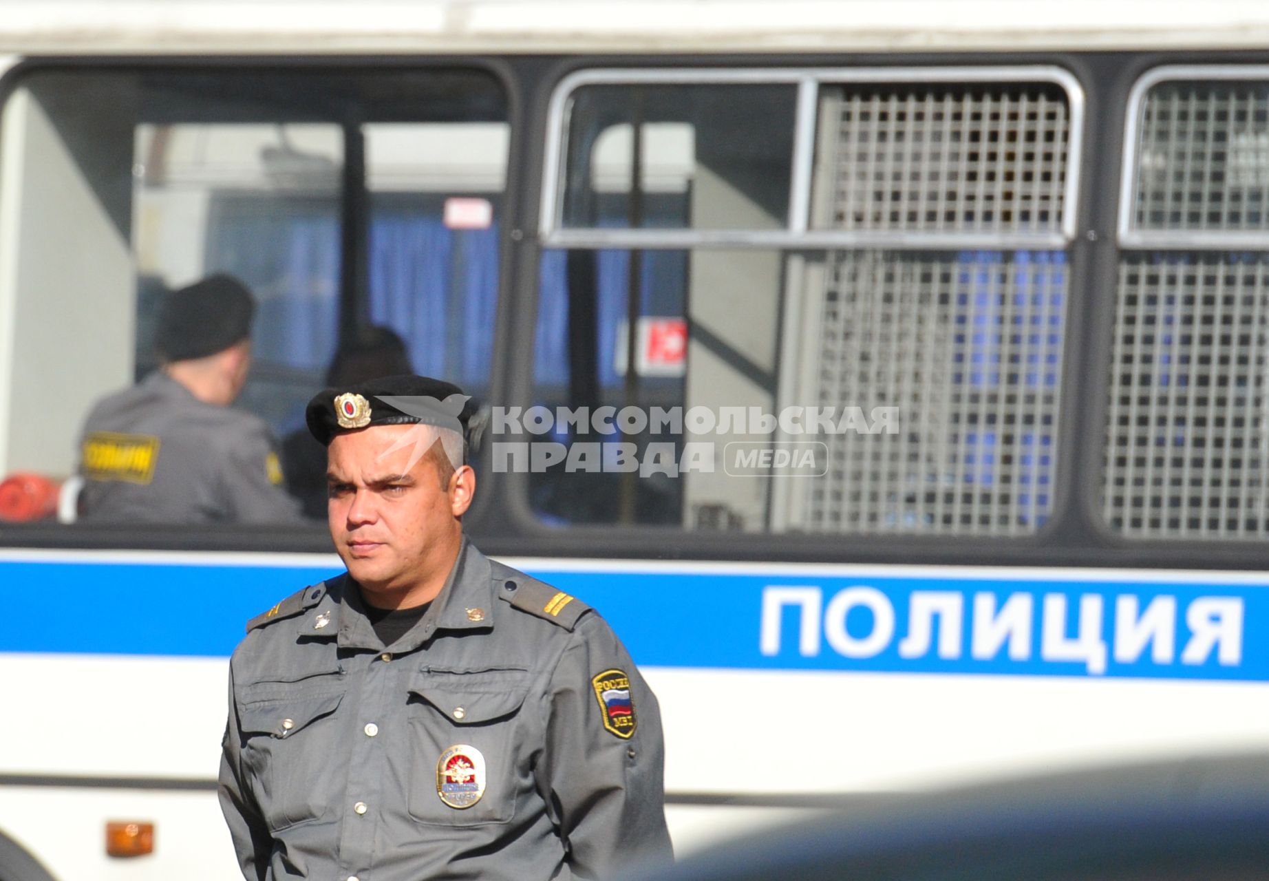 Полиция. На снимке: сотрудник правохранительных органов у полицейской автомашины.