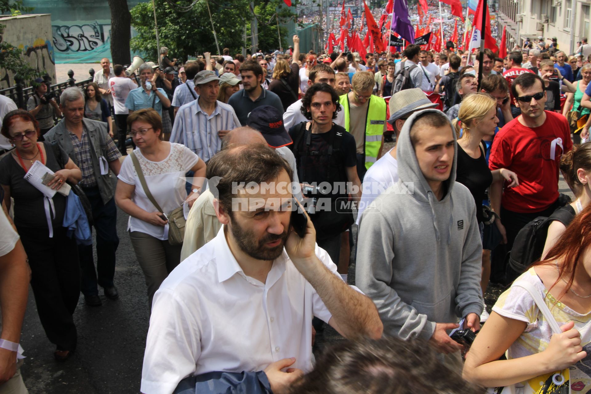 Акция оппозиции `Марш миллионов`.  На снимке: член комитета Государственной думы РФ по экономической политике, инновационному развитию и предпринимательству Илья Пономарев (с мобильным телефоном) во время шествия от Пушкинской площади до проспекта Сахарова.