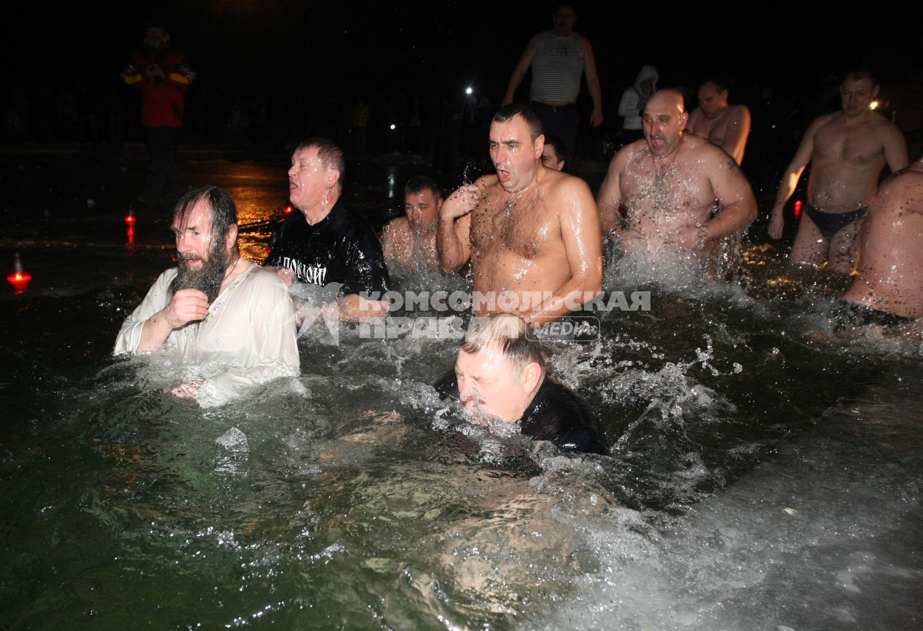 Люди коллективно заходят в воду, крестятся на ходу.