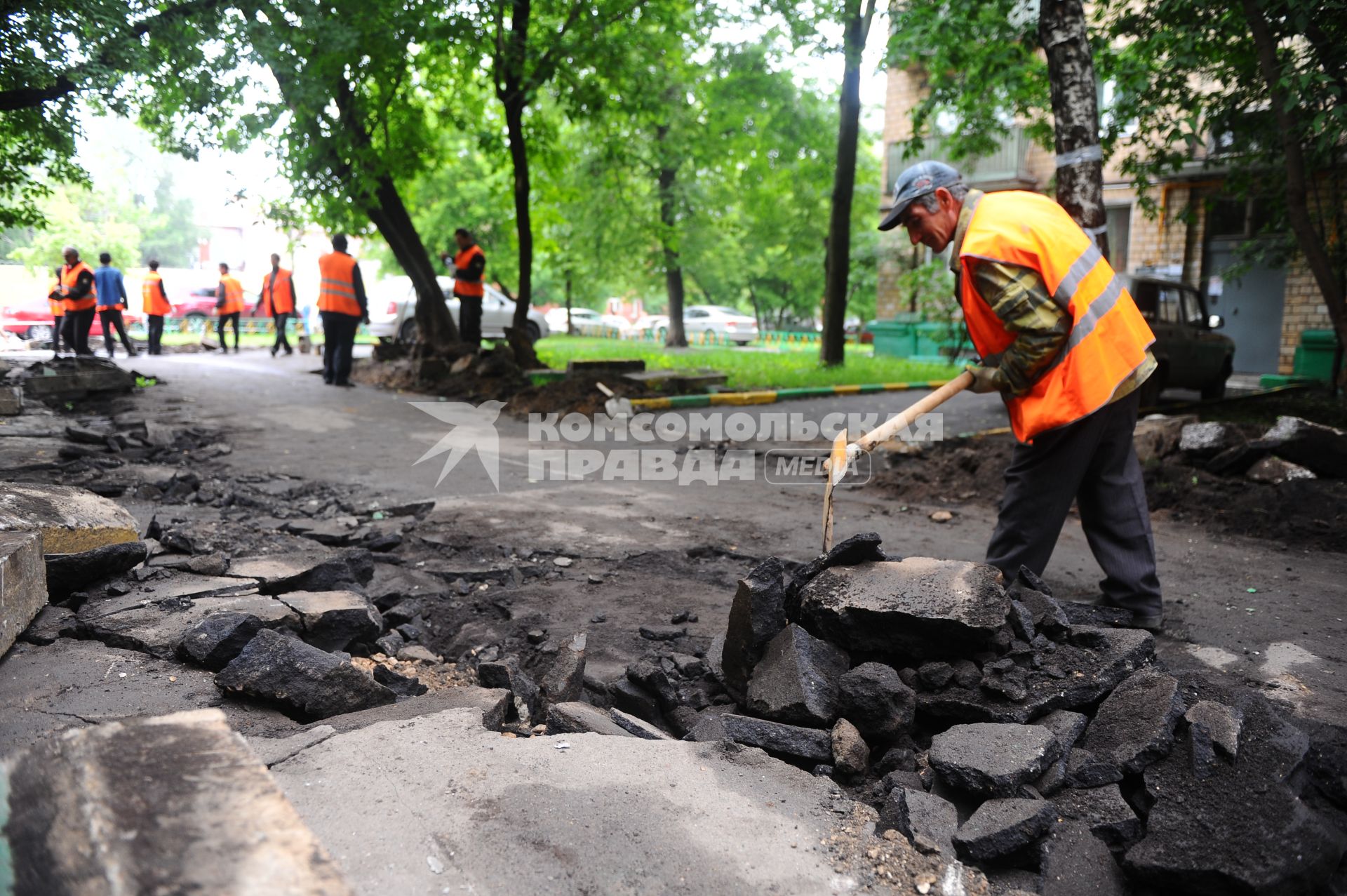 Гастарбайтеры разбивают асфальт во дворе дома.