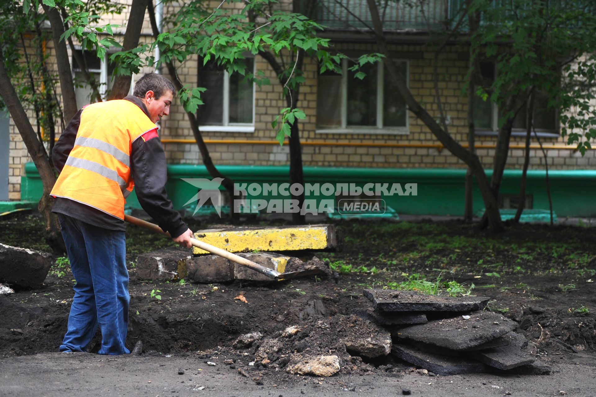 Гастарбайтер разбивает асфальт во дворе дома.