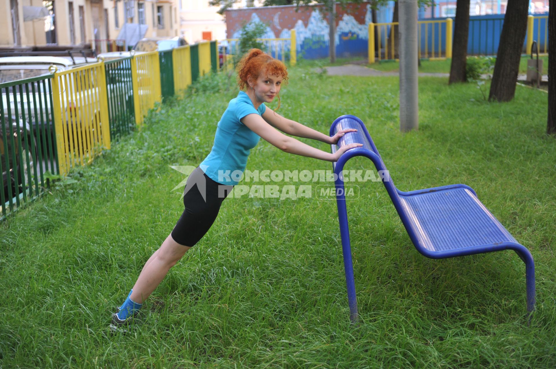 Девушка занимается фитнесом на природе.