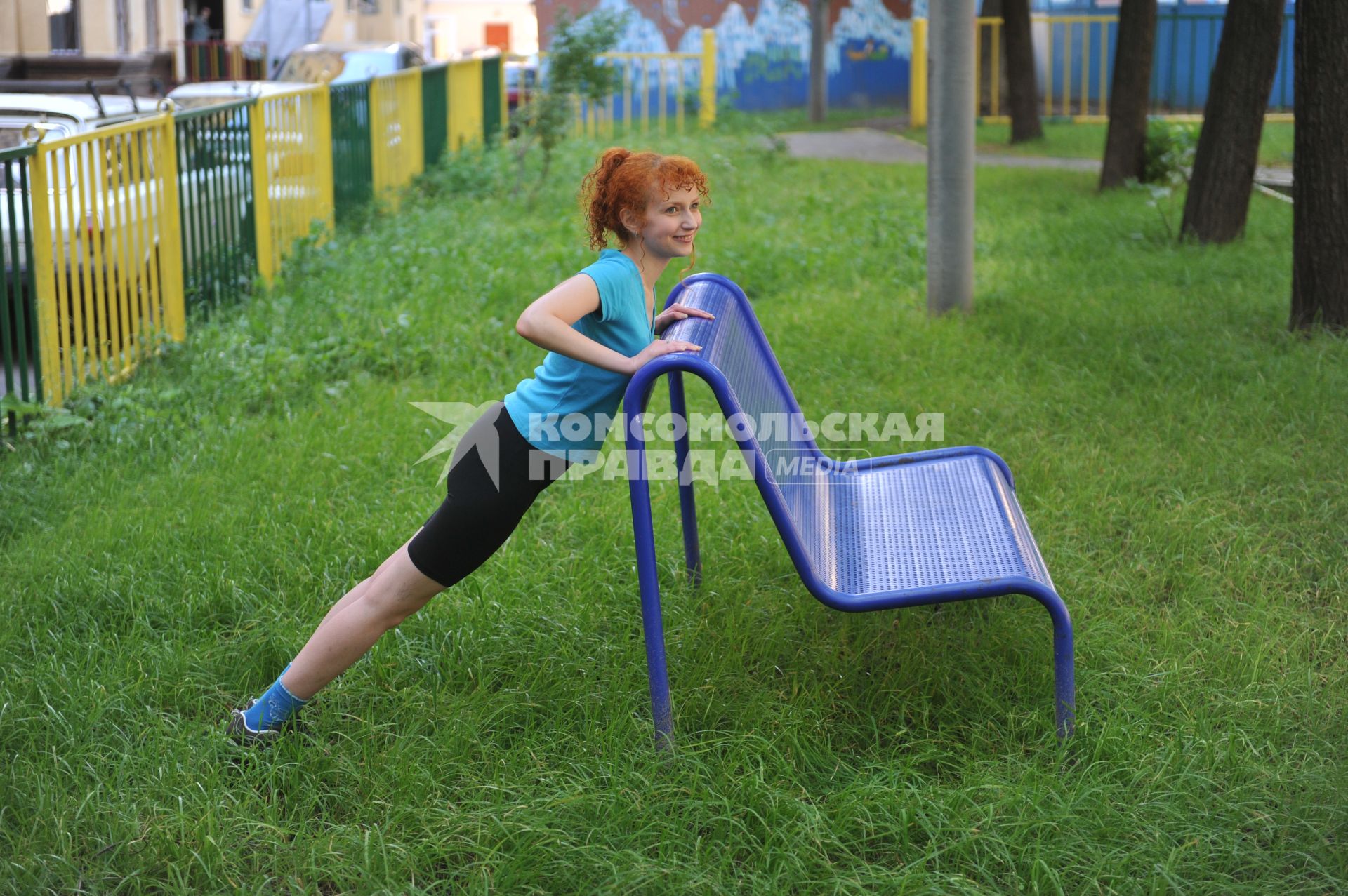 Девушка занимается фитнесом на природе.