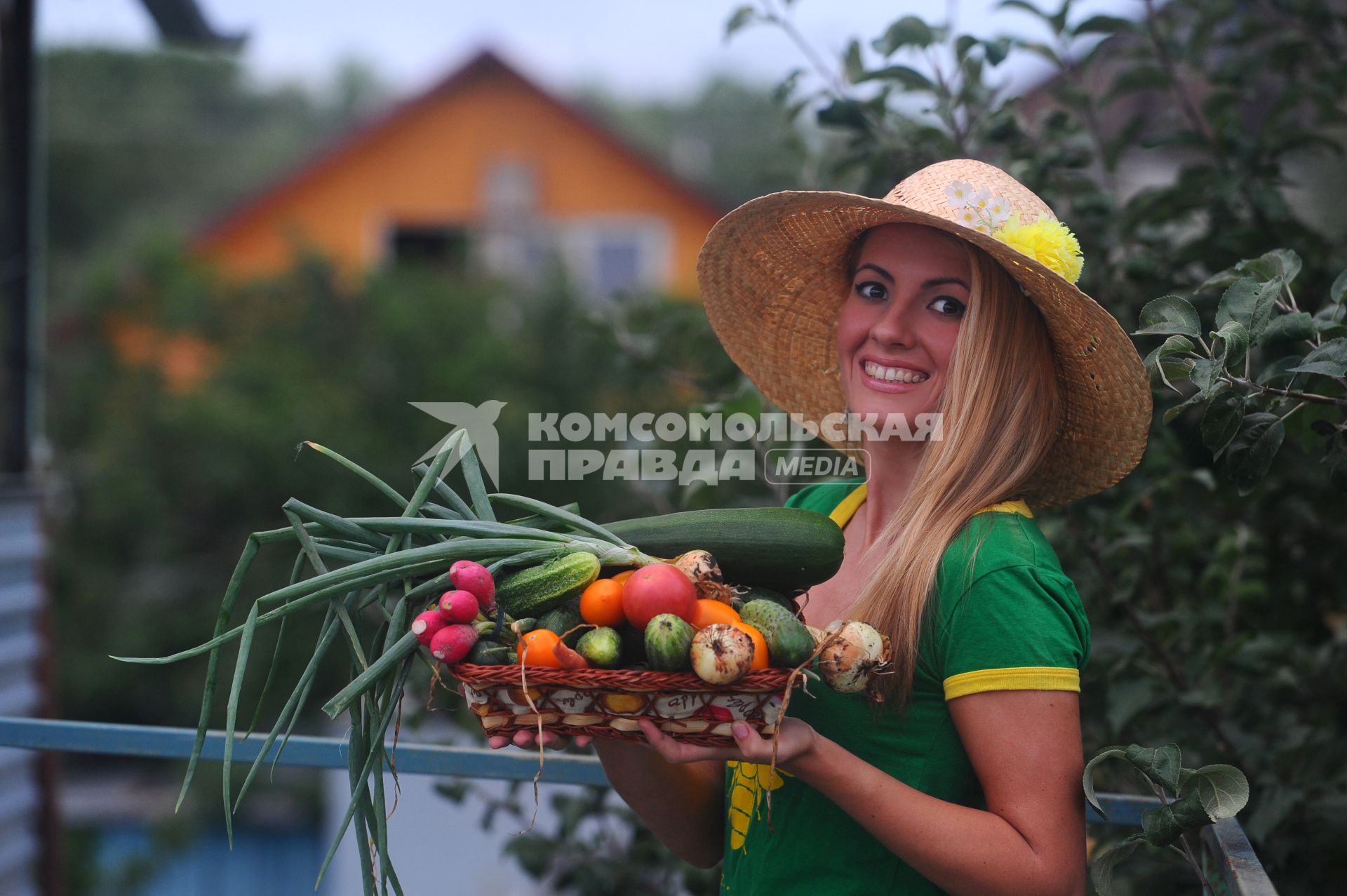 Дача. Девушка держит в руках корзину с овощами.