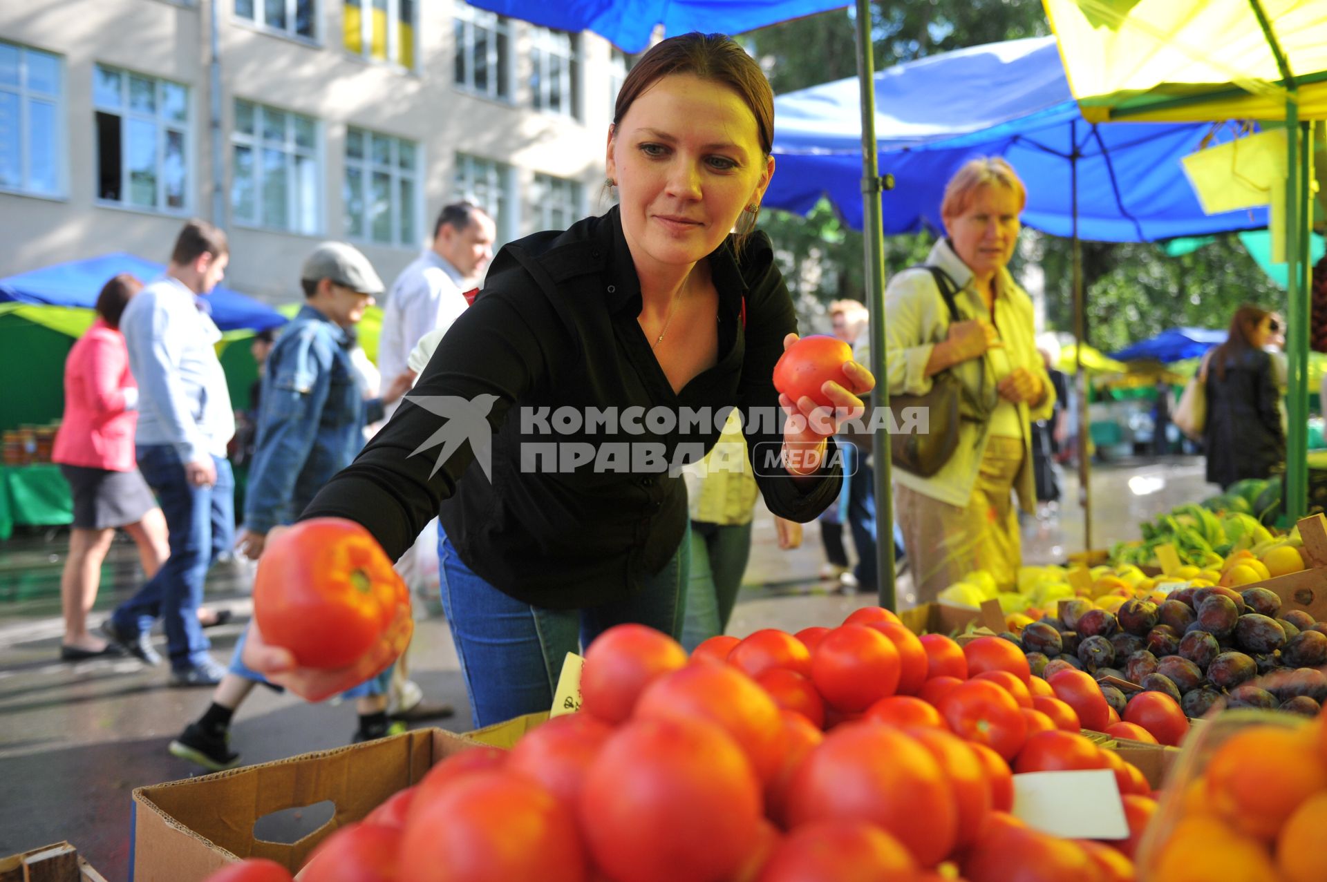 Ярмарка выходного дня. На снимке: женщина покупает продукты.