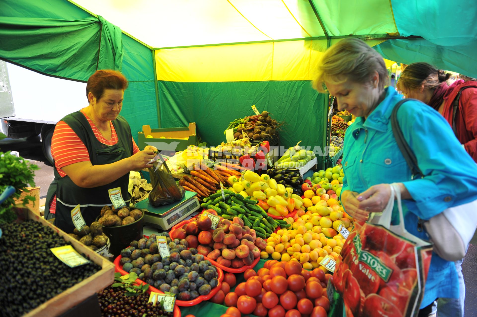 Ярмарка выходного дня. На снимке: женщина покупает продукты.