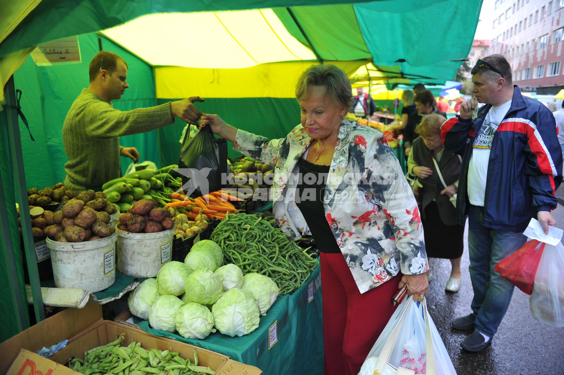 Ярмарка выходного дня. На снимке: женщина покупает продукты.