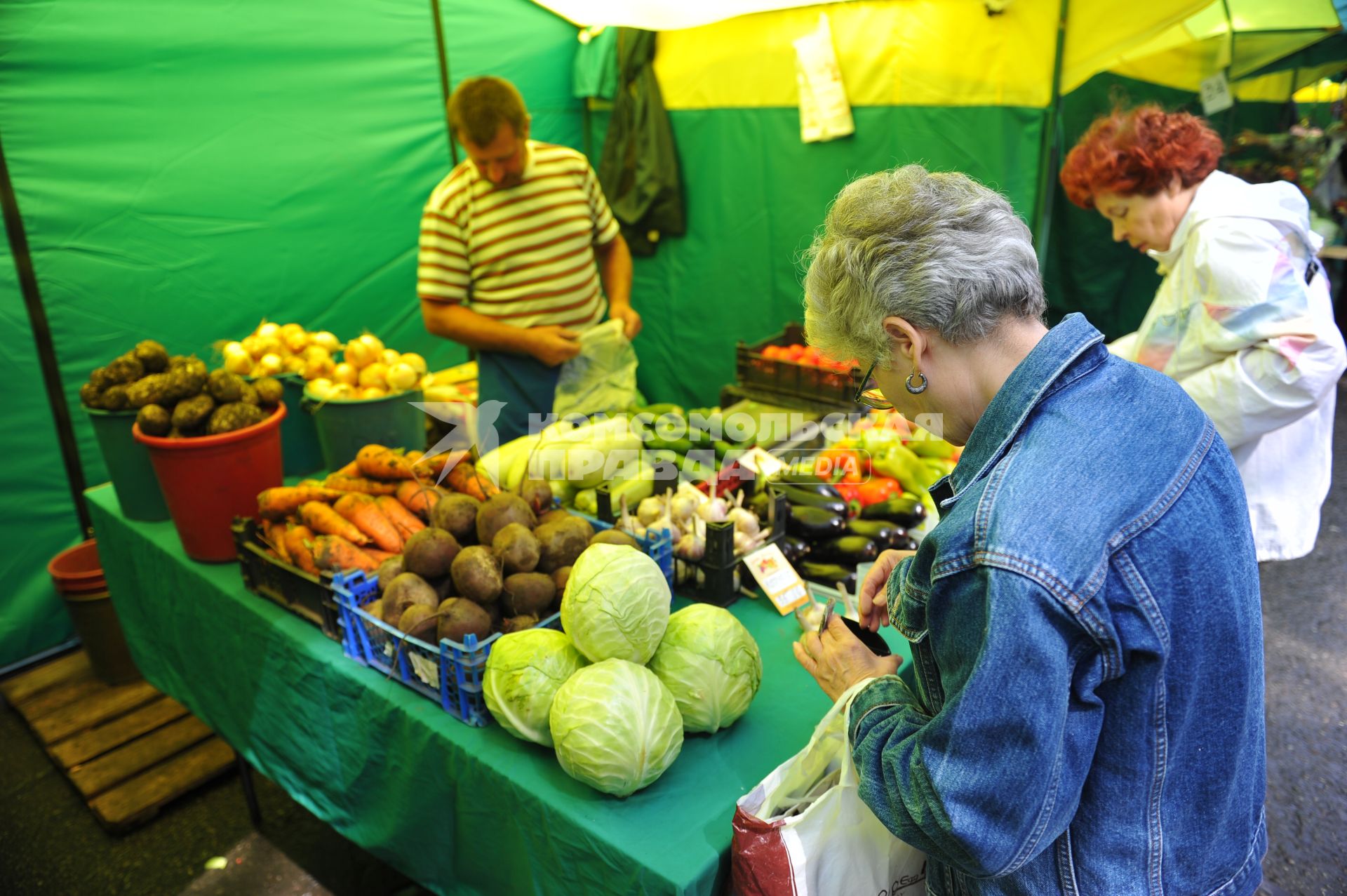 Ярмарка выходного дня. На снимке: женщина покупает продукты.