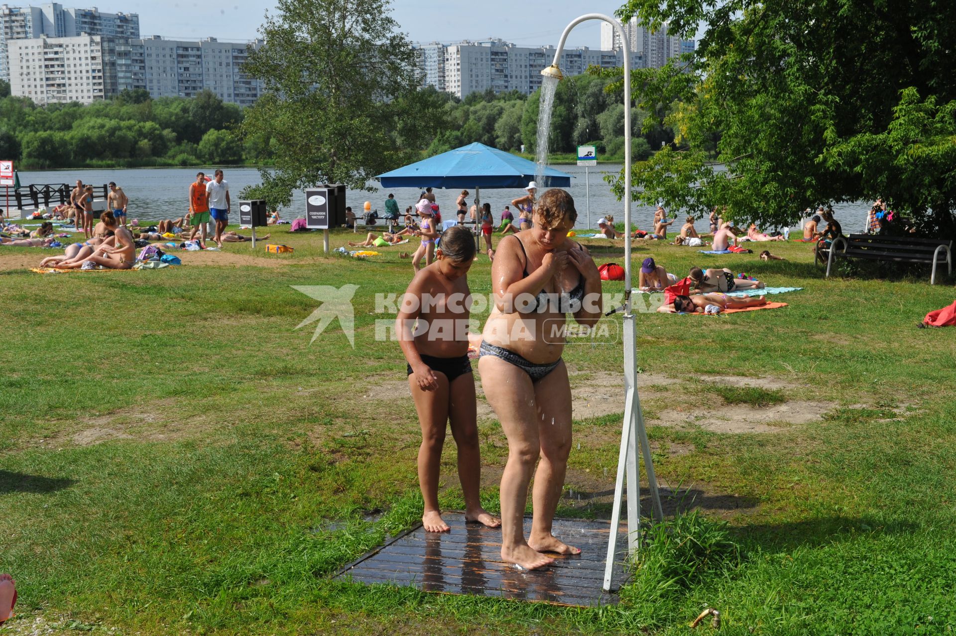 Пляж `Серебряный бор`. На симке: женщина принимает душ на пляже.