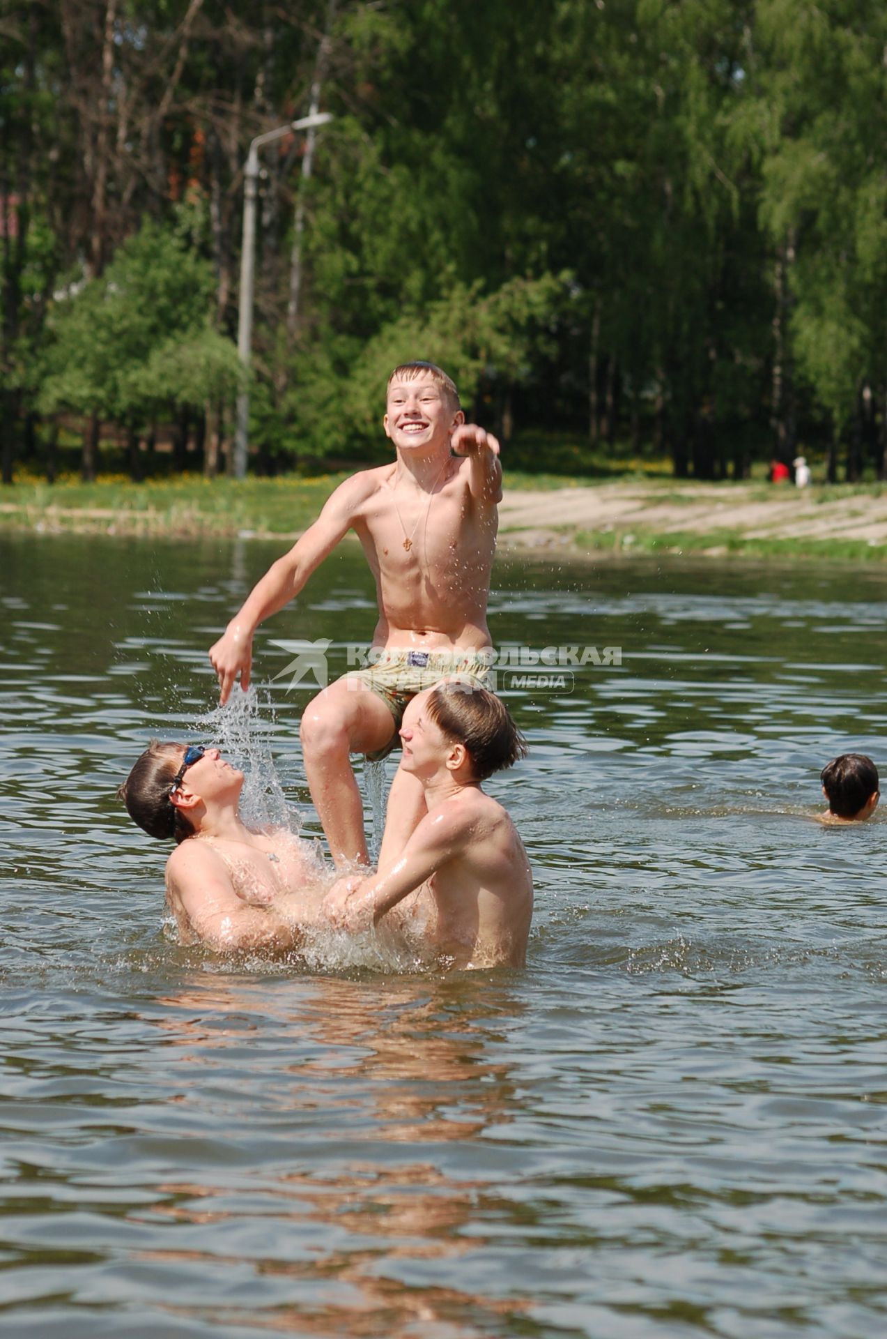 Дети купаются в водоеме, прыгают в воду.