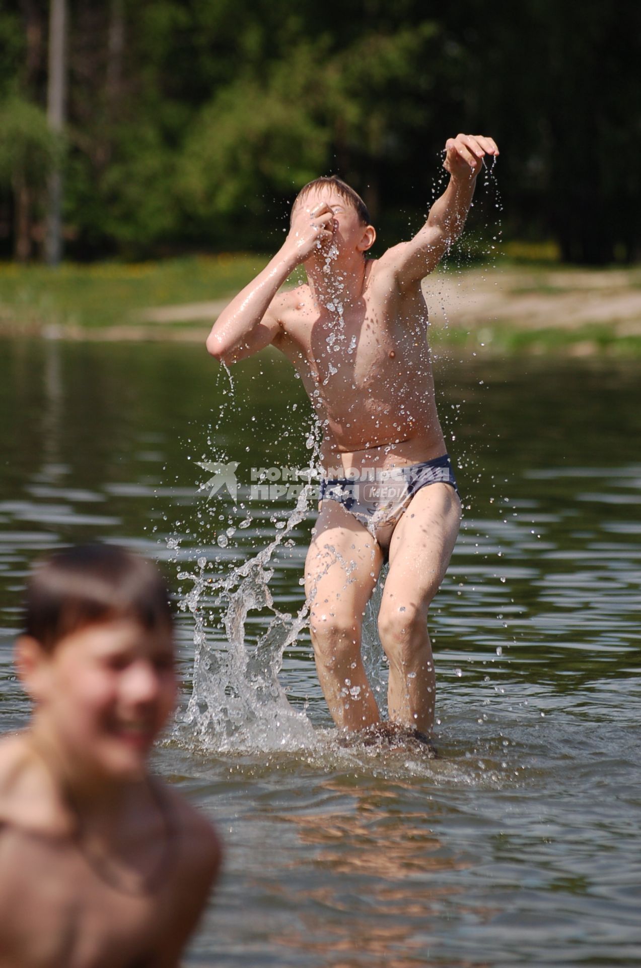 Дети купаются в водоеме, прыгают в воду.