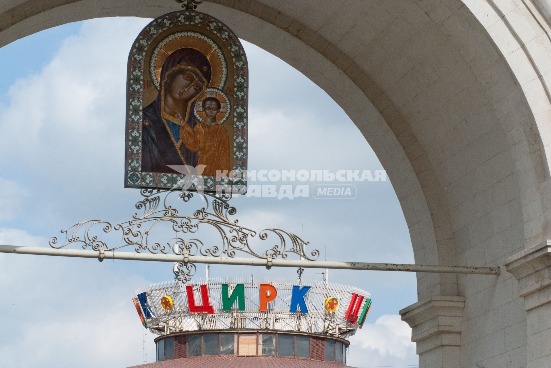 В арке висит образ (икона) Богородицы с младенцем Хрситом в руках, на фоне циркового купола.