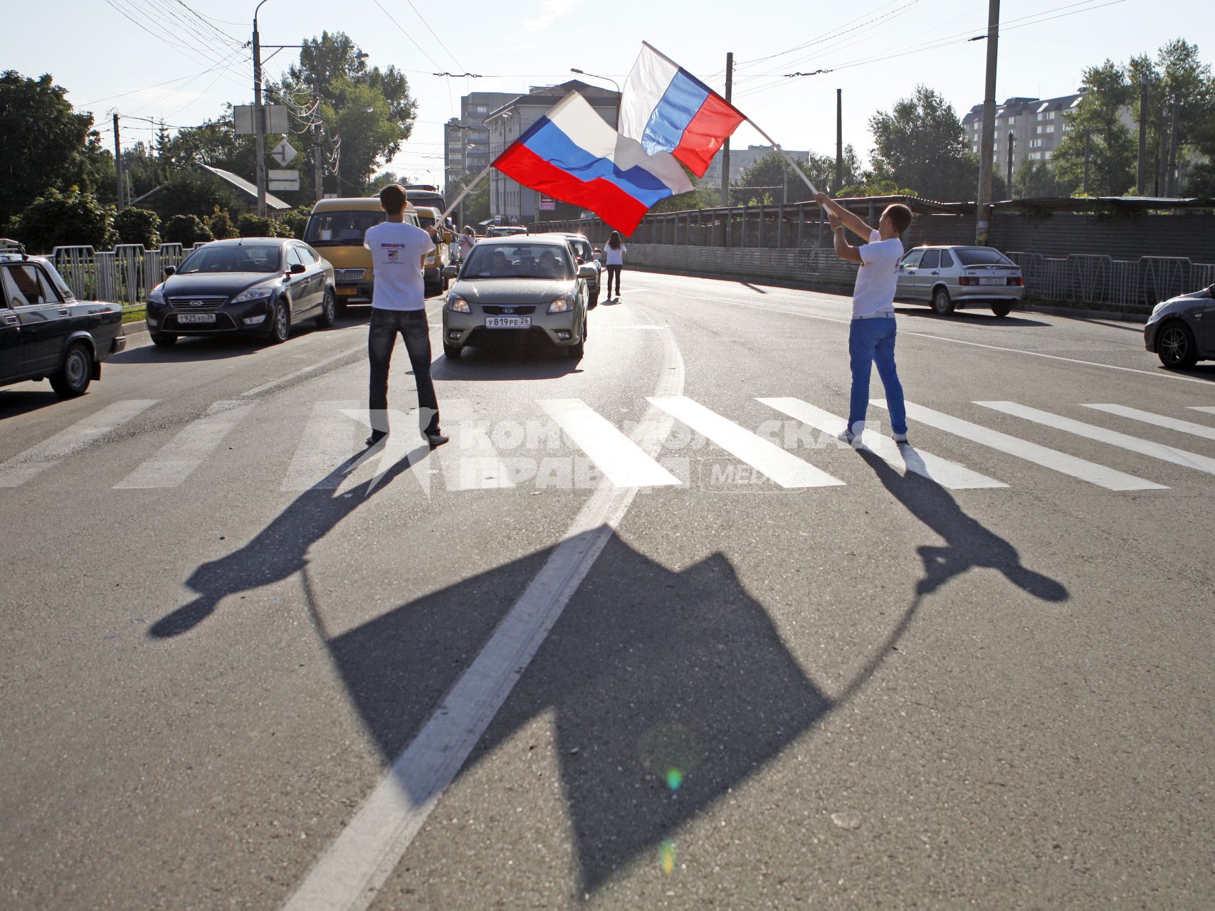 Волонтеры поздравляют автомобилистов с днем флага. На снимке: мужчины с российским флагом в руках.