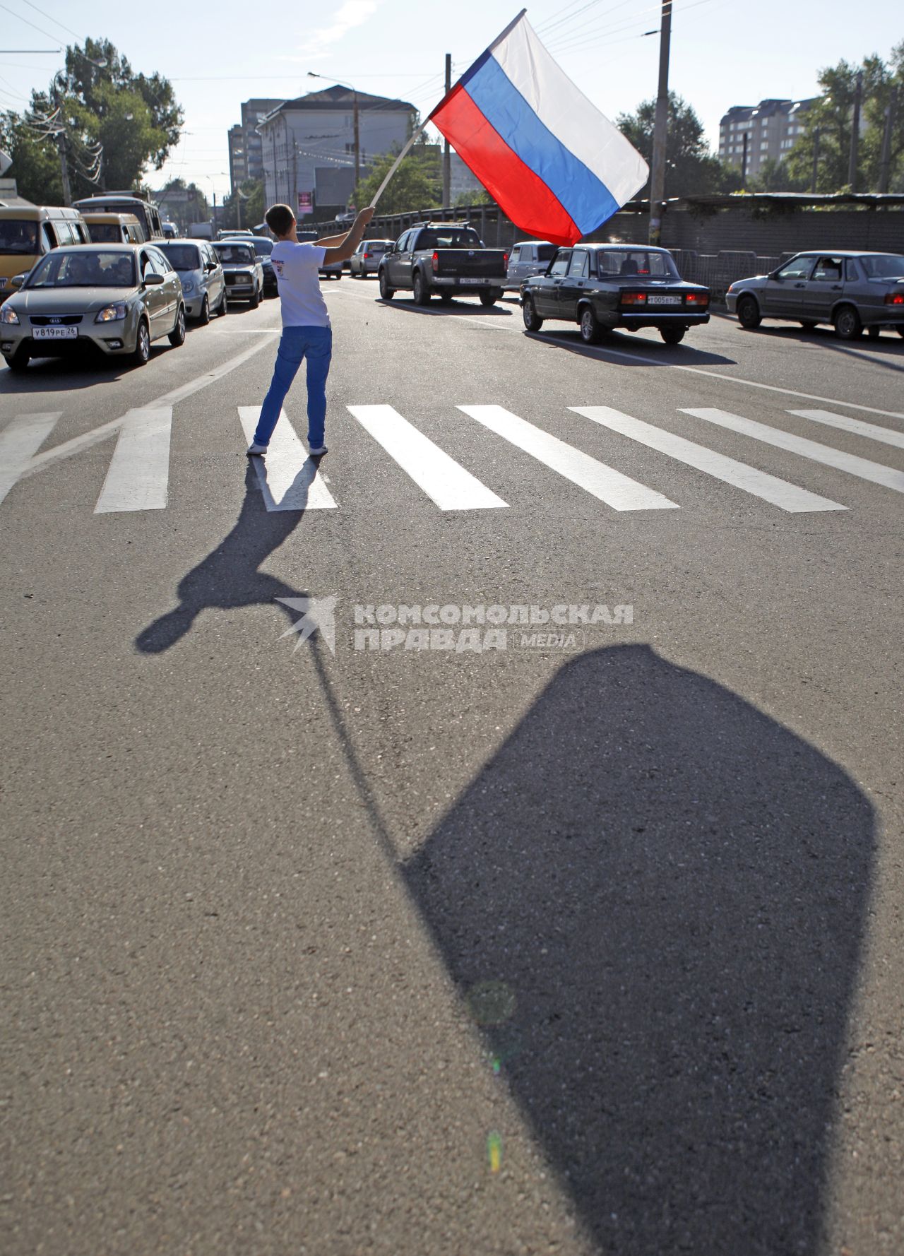 Волонтеры поздравляют автомобилистов с днем флага. На снимке: мужчина с российским флагом в руках.