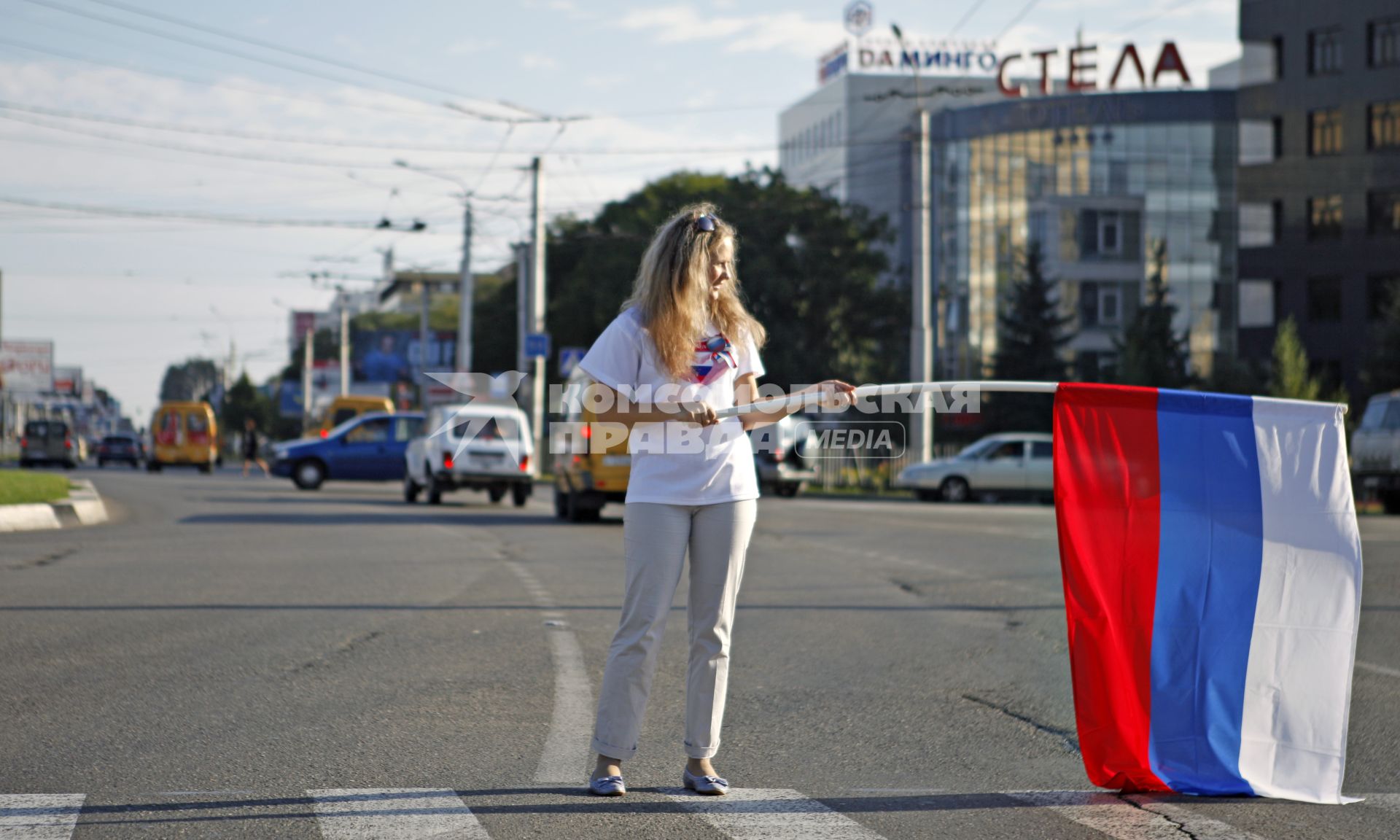 Волонтеры поздравляют автомобилистов с днем флага. На снимке: девушка с российским флагом в руках.