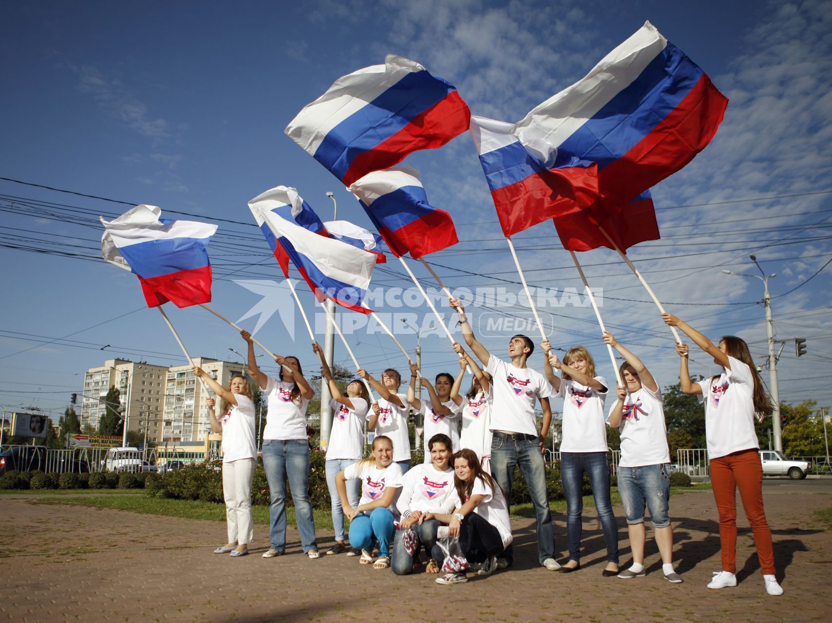 Волонтеры поздравляют автомобилистов с днем флага. На снимке: люди с российским флагом в руках.