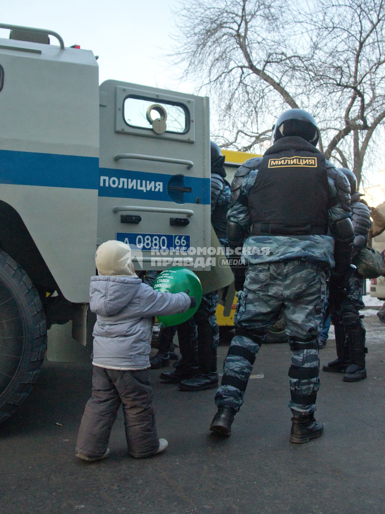 Ребенок протягивает воздушный шарик полицейскому.