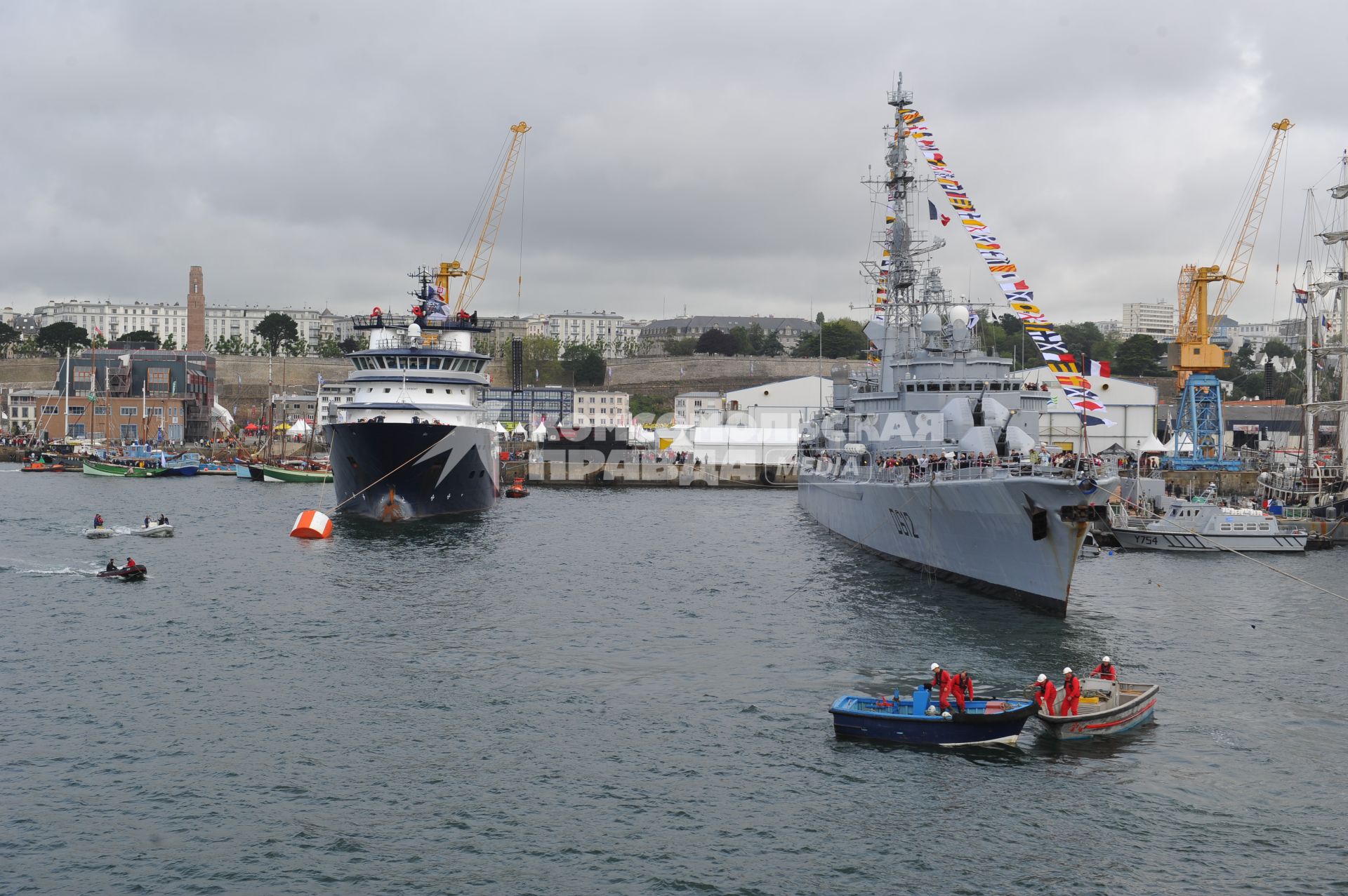 Военный корабль стоит у причала в порту.