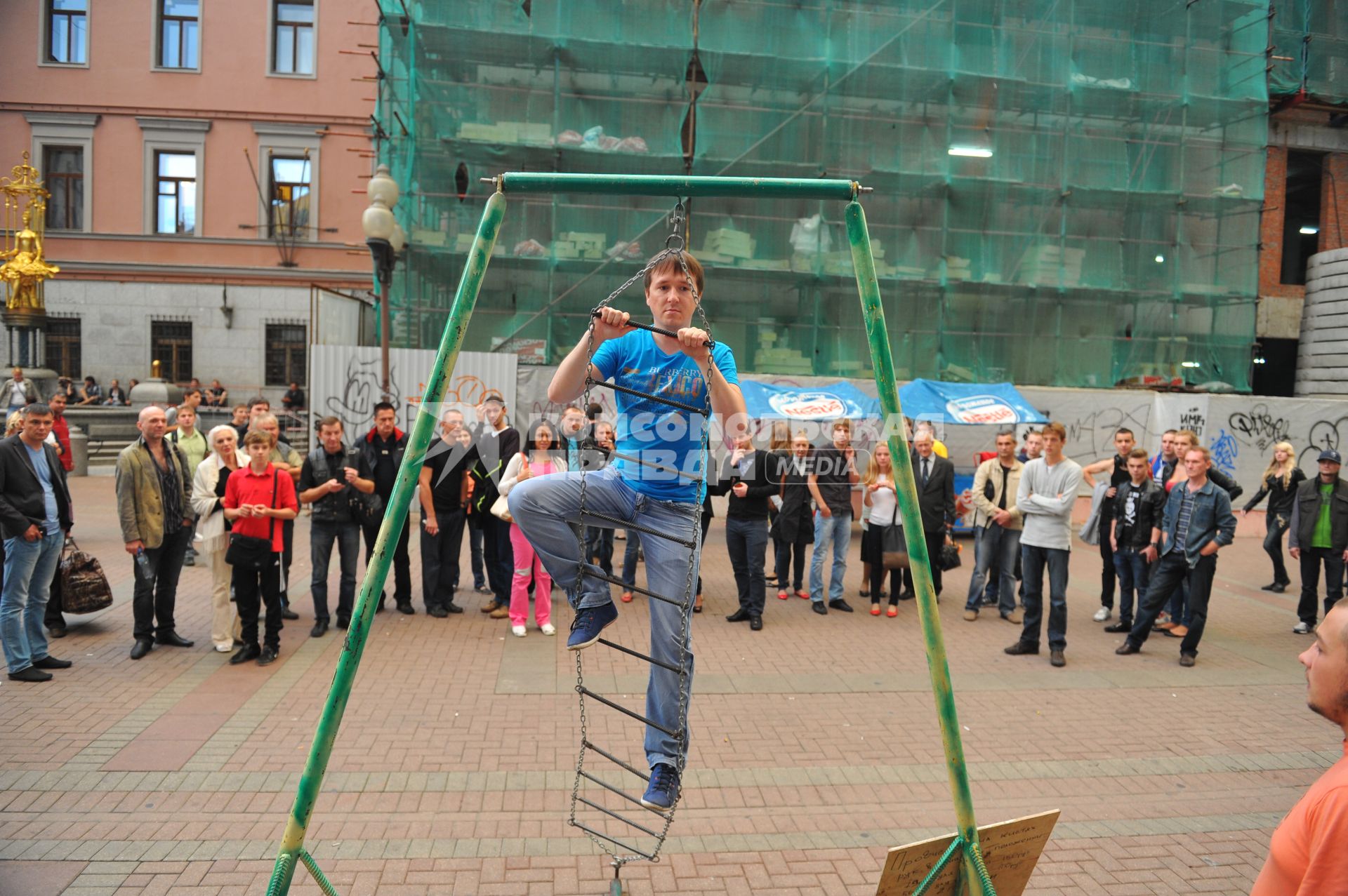 Представление на Старом Арбате. На снимке: мужчина на подвесной лестнице.