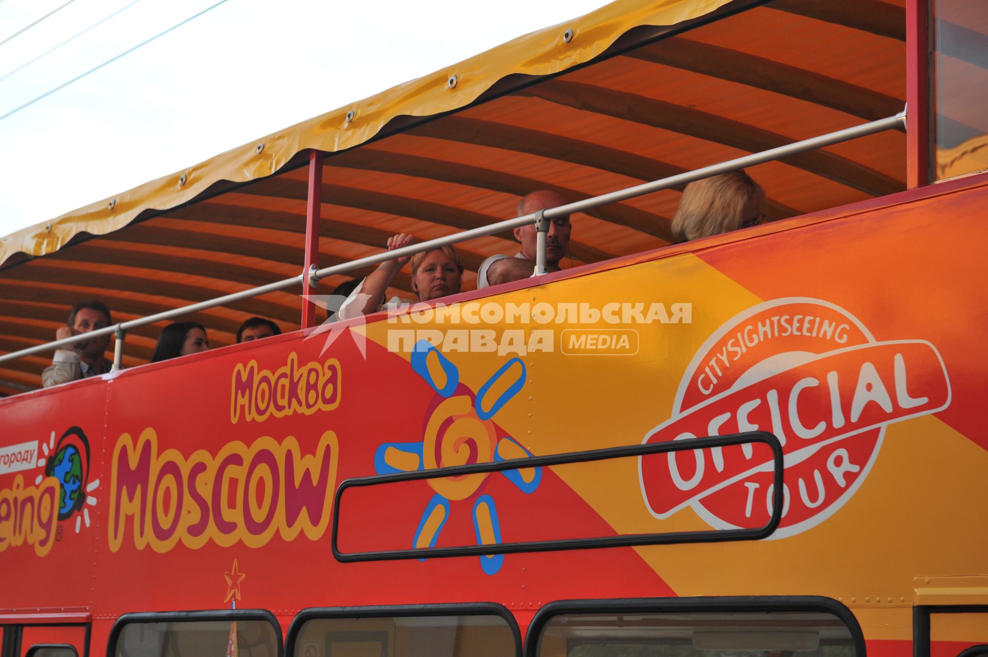 Двухэтажный автобус возит туристов по центру Москвы.