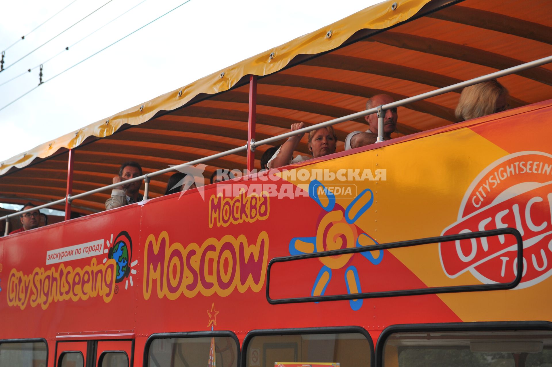 Двухэтажный автобус возит туристов по центру Москвы.