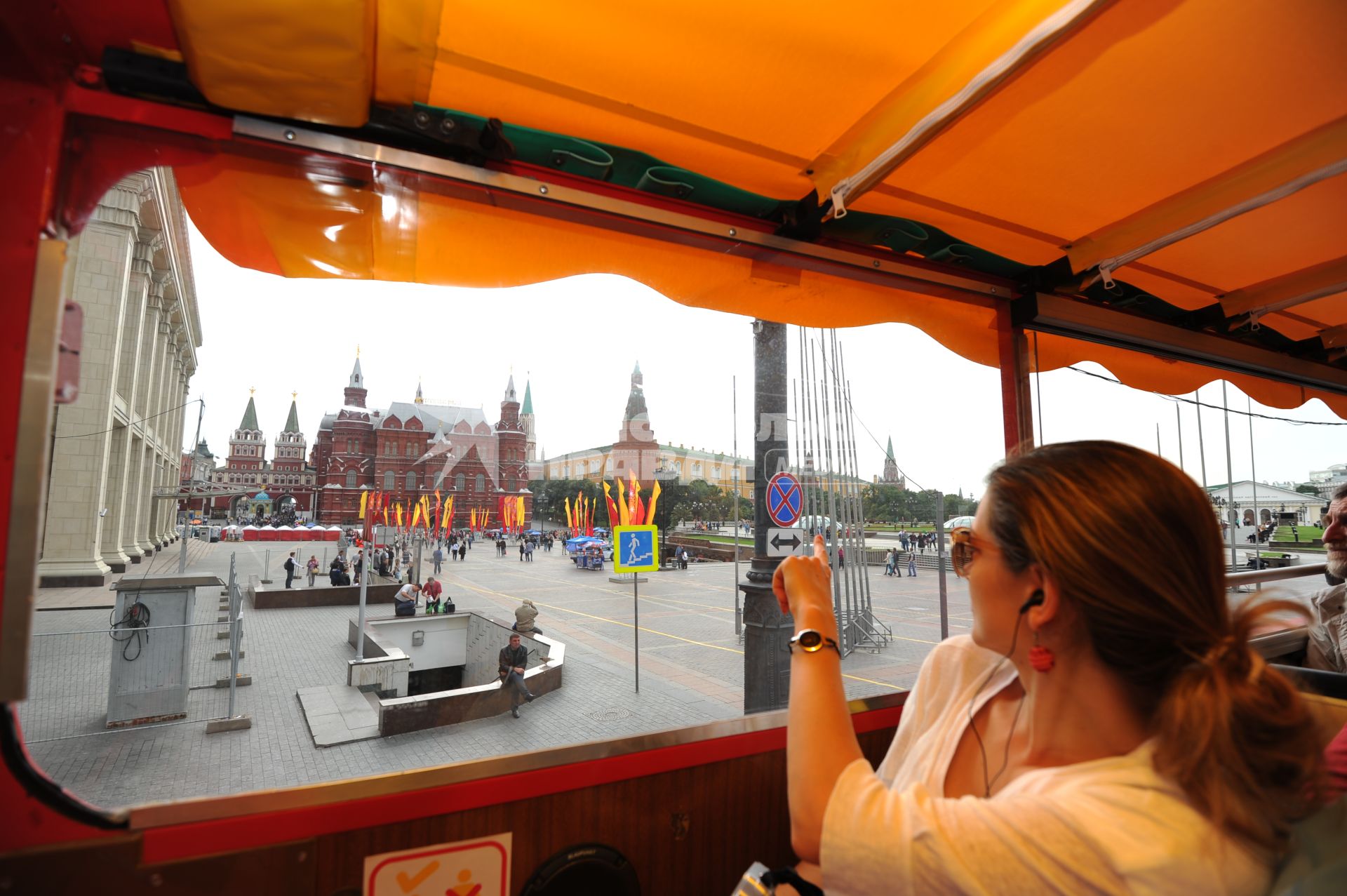Двухэтажный автобус возит туристов по центру Москвы. На снимке: туристы проезжают Манежную площадь.