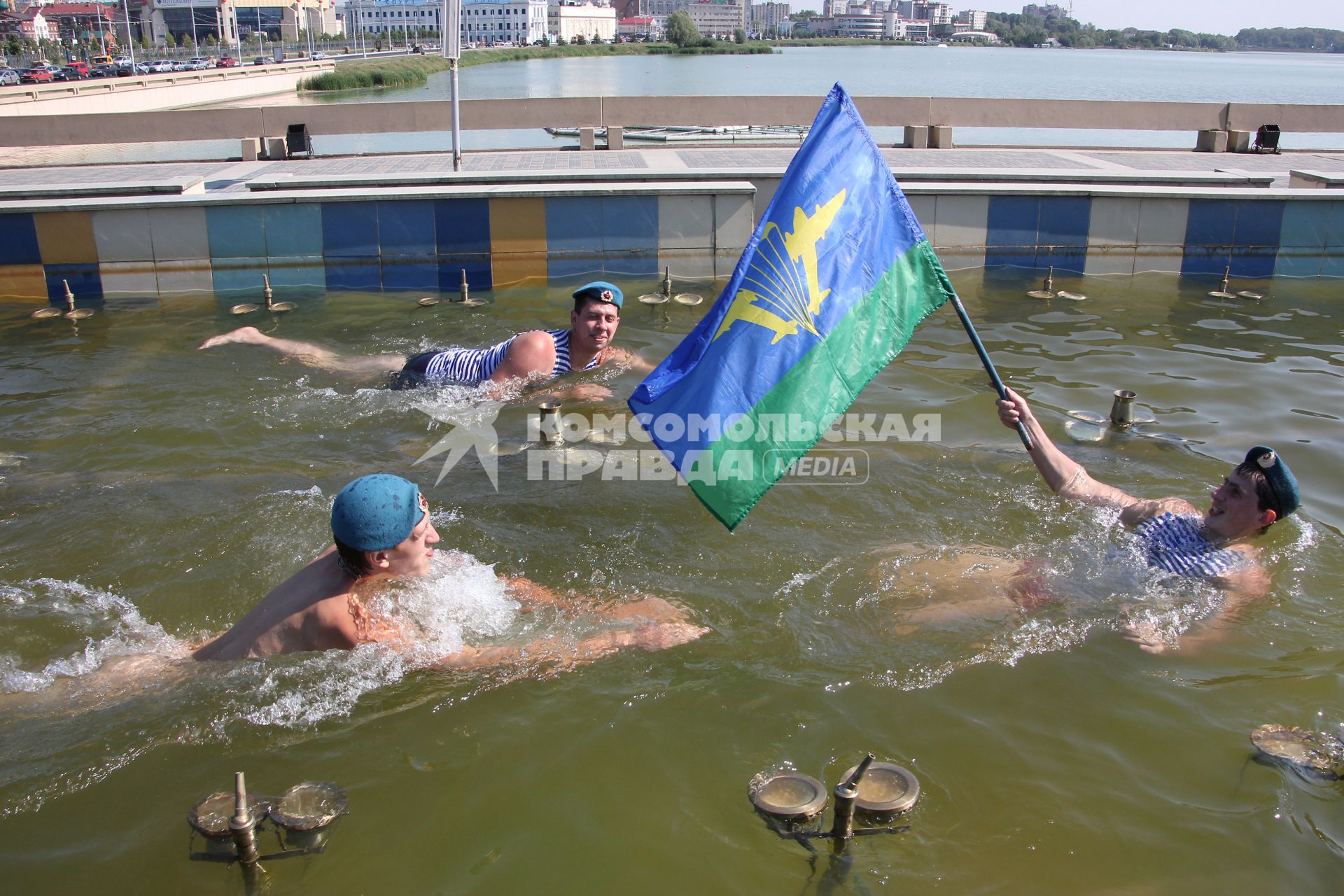 Празднование дня ВДВ в Казани. На снимке: Десантник с флагом воздушно-десантных войск плывет в фонтане рядом плывут сослуживцы.