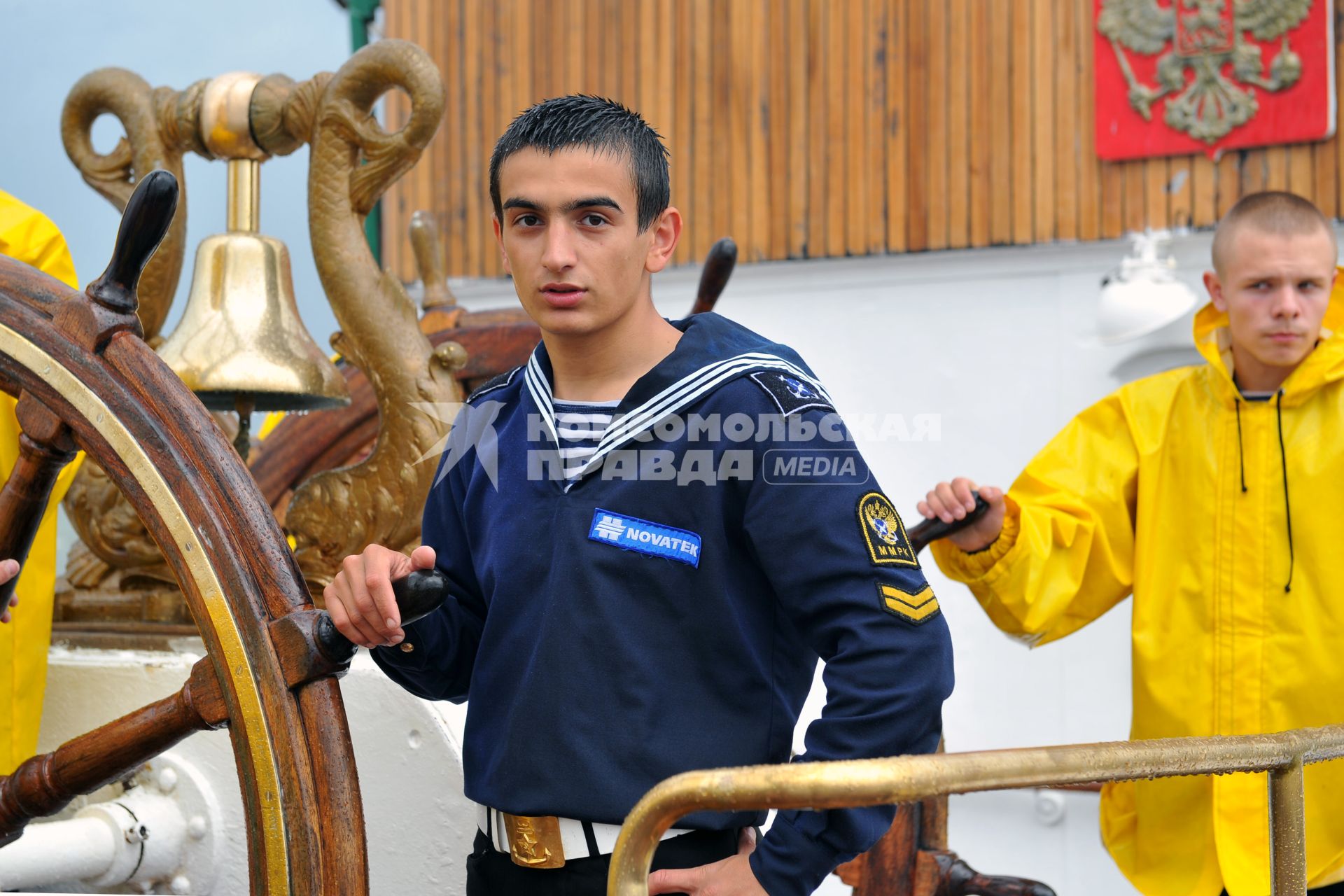 Барк `Седов` перед началом своего первого кругосветного путешествия. На снимке: курсанты морской академии стоят у штурвала.