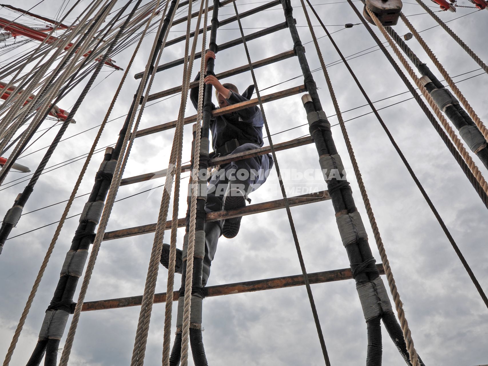 Барк `Седов`. На снимке: курсант поднимается по канатам на мачту корабля.