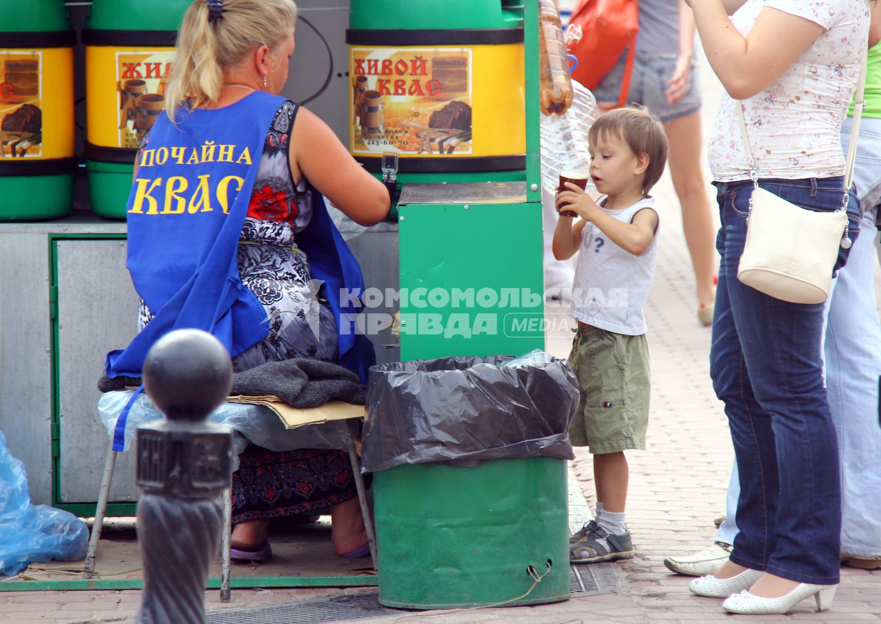 Продажа кваса на улице. Ребенок в ожидании напитка.