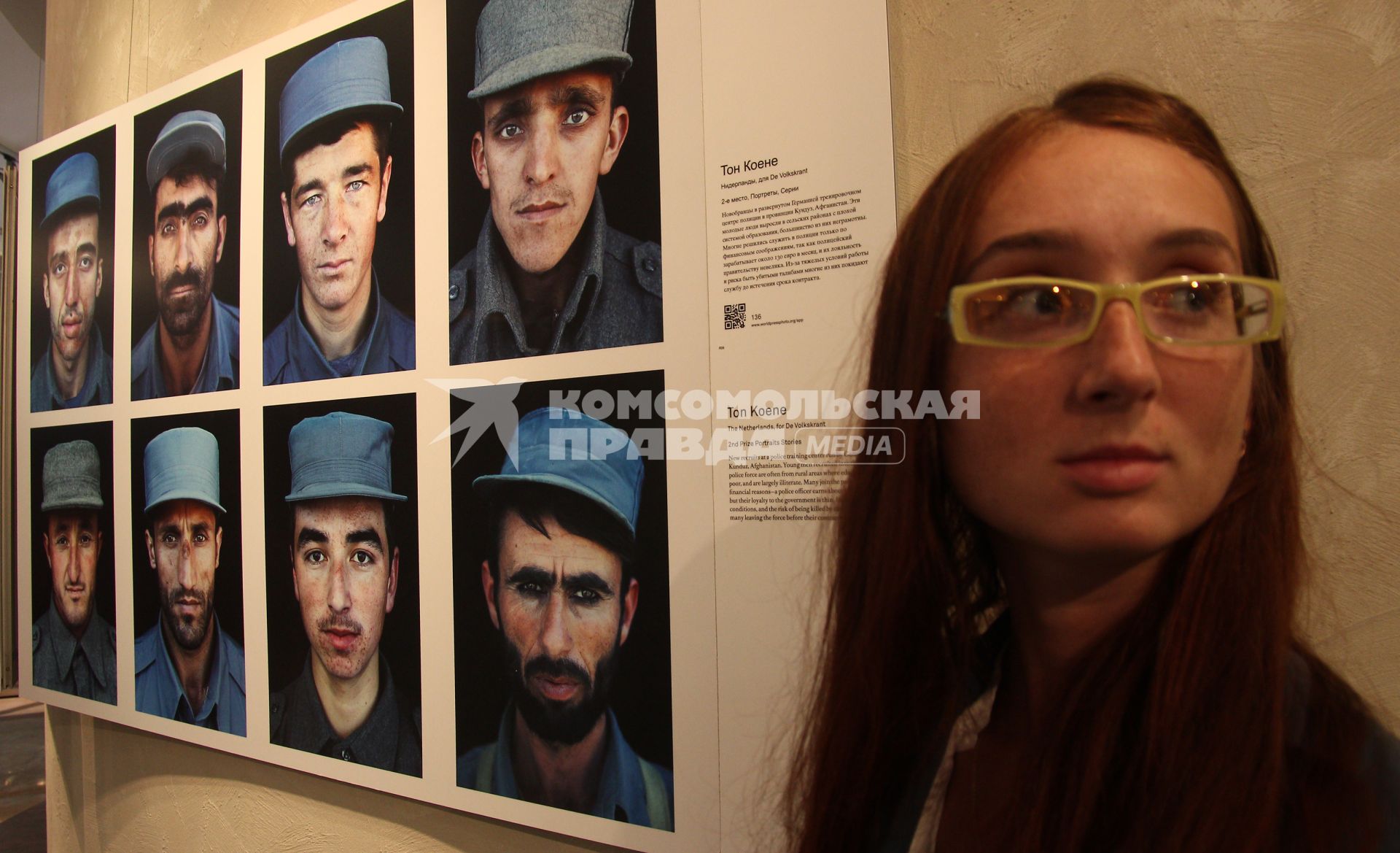 Фотовыставка `World press photo 2012`. На снимке: девушка на фоне экспозиции.