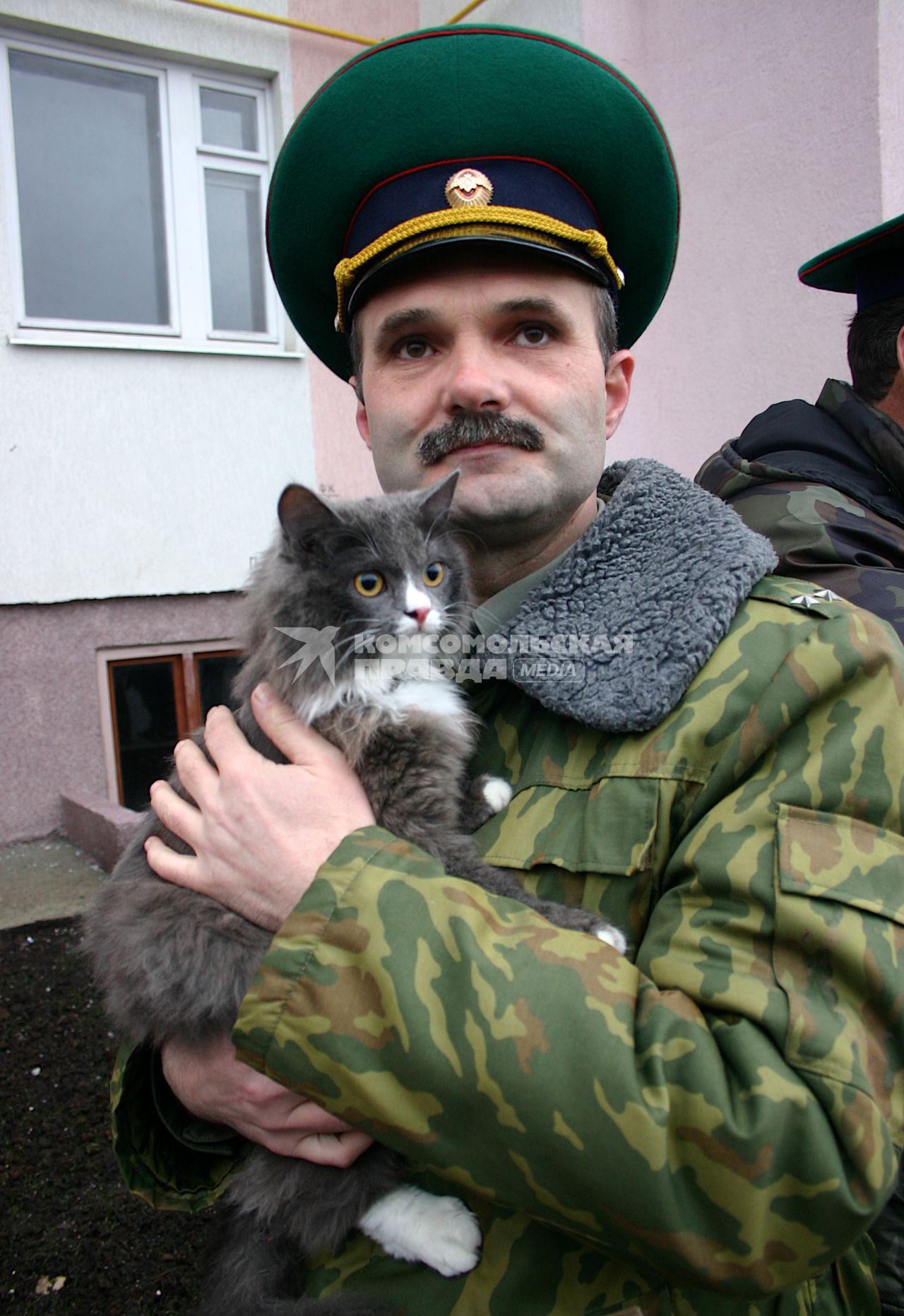 Военный готовится к получению жилья, держит на руках кошку.