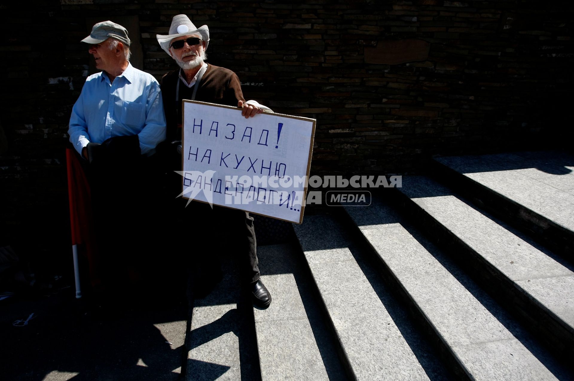 В Калининграде прошел согласованный с властями митинг в поддержку Московского `Марша миллионов`. На снимке: Два мужчины стоят на лестнице, один из них держит в руках плакат: `Назад! На кухню, бандерлоги!..`