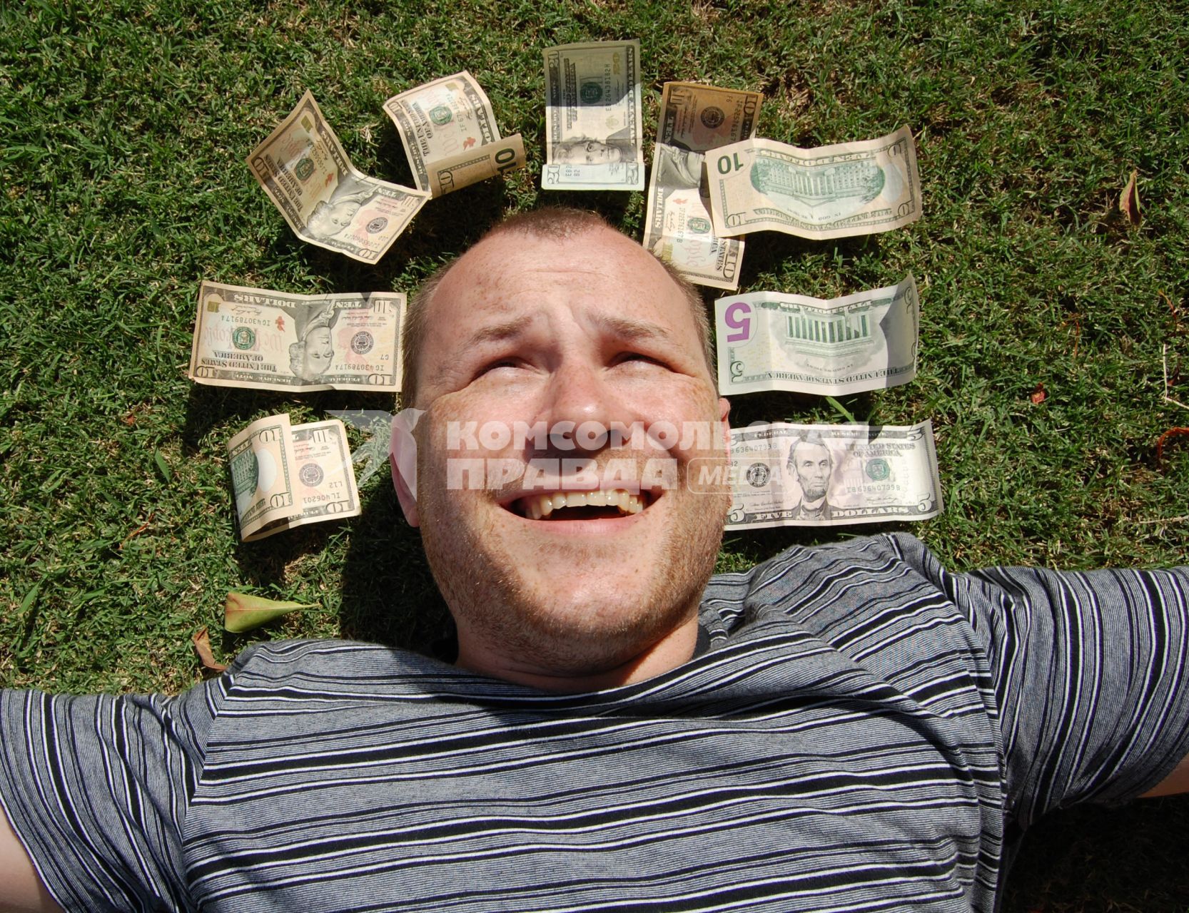 Мужчина в окружении долларовых банкнот.