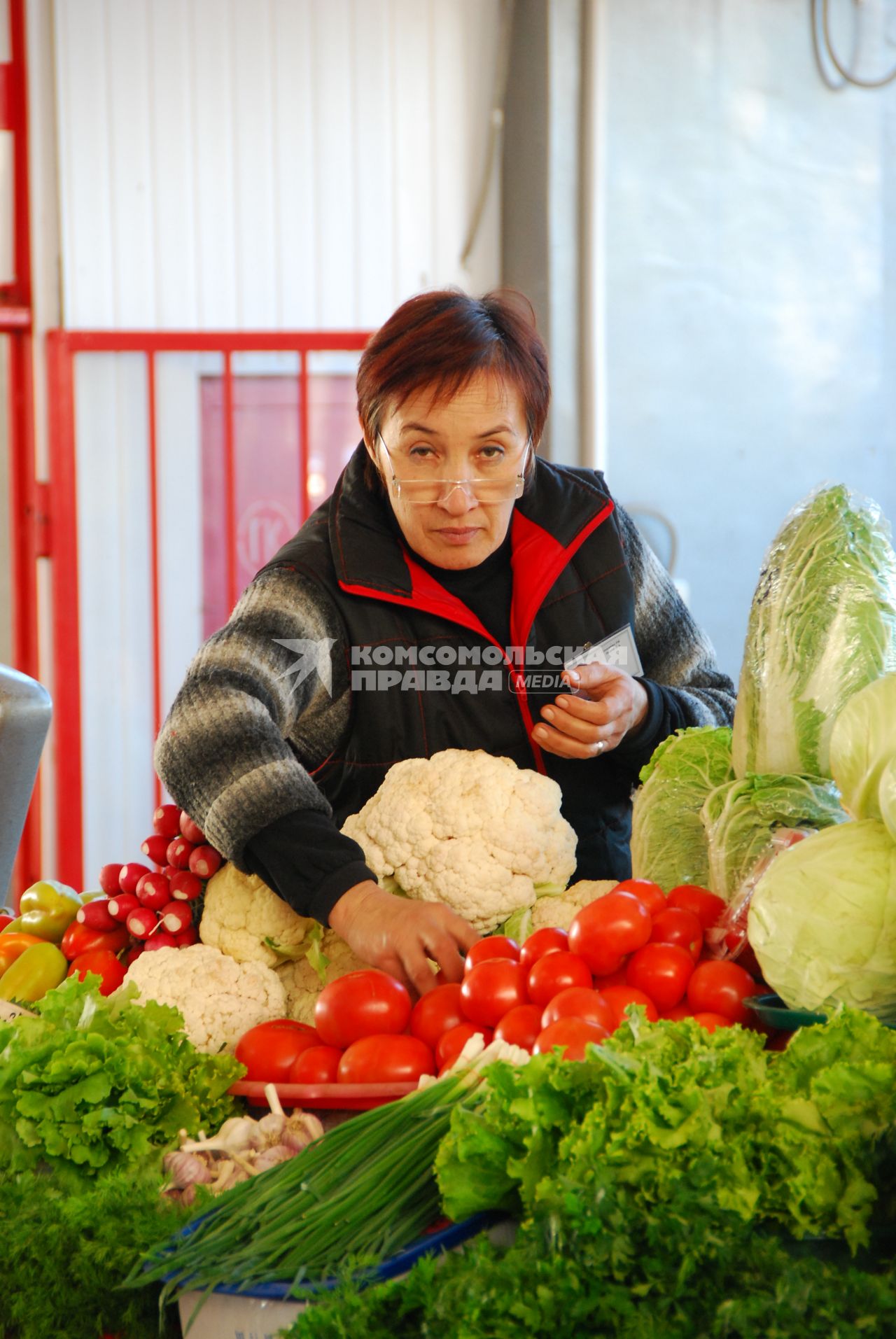 Продавец в овощном отделе на рынке.