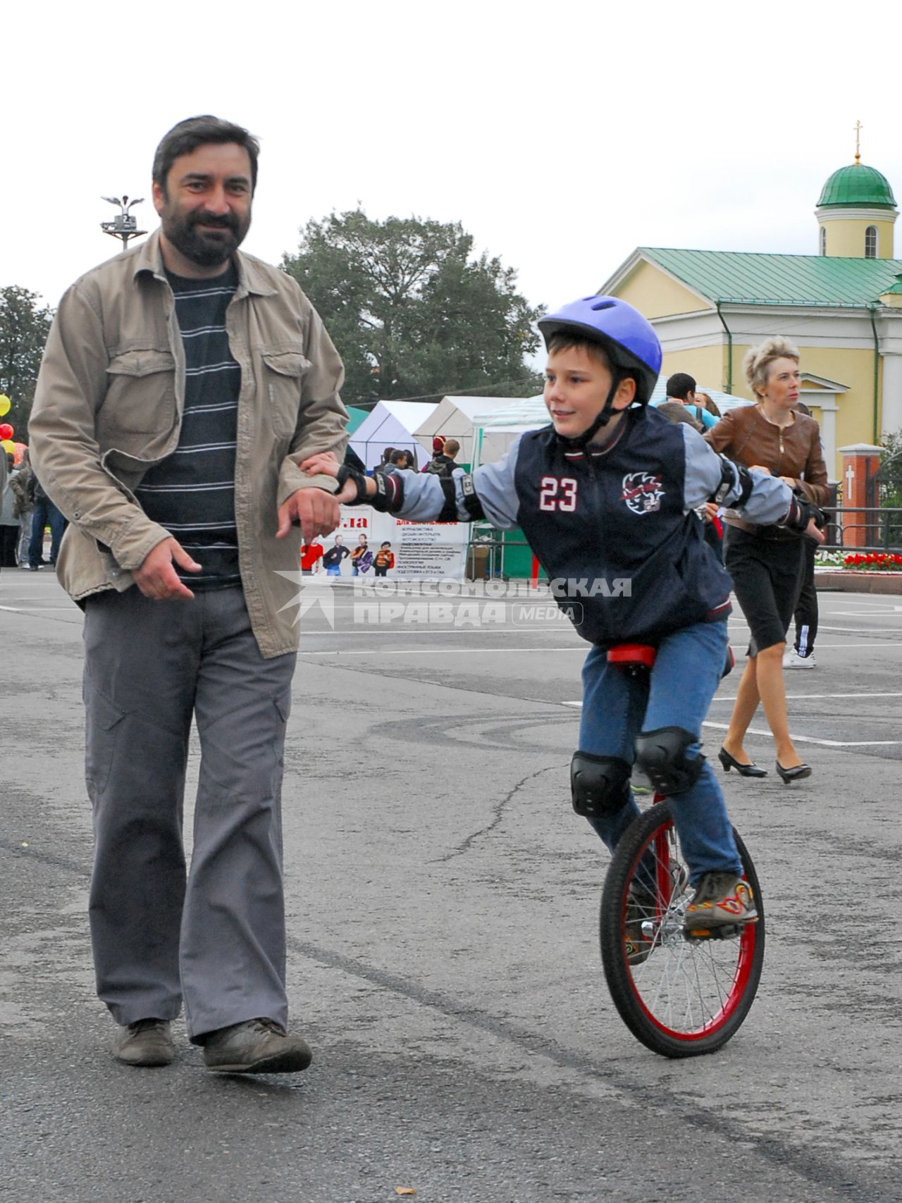 Мальчик едет на одноколёсном велосипеде.