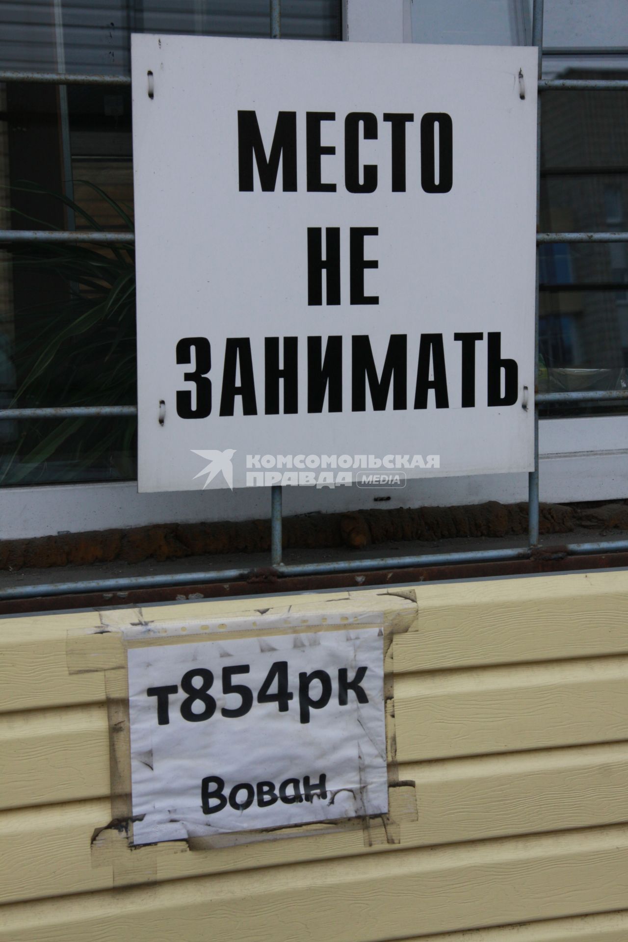 Парковка возле офиса. Надпись: `Место не занимать`.