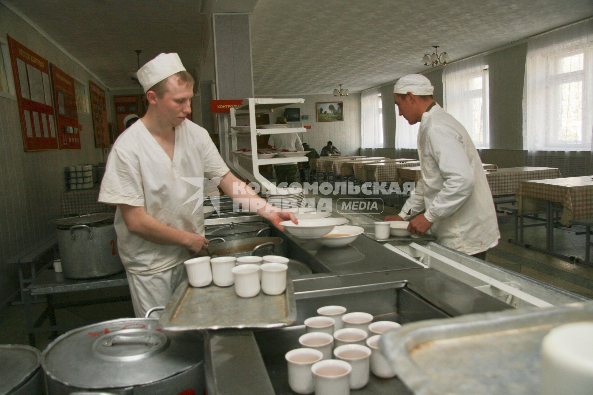 Солдатская столовая в воинской части. Повар накладывает еду в тарелки.