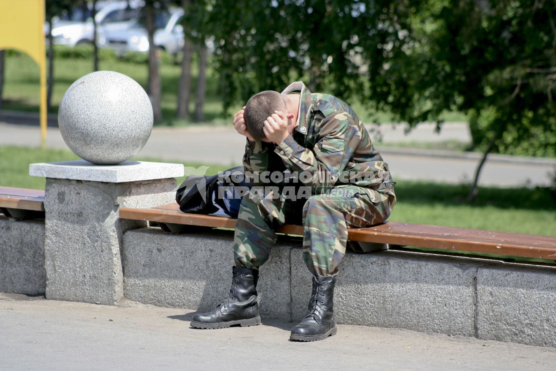 Военный сидит обхватив голову руками.